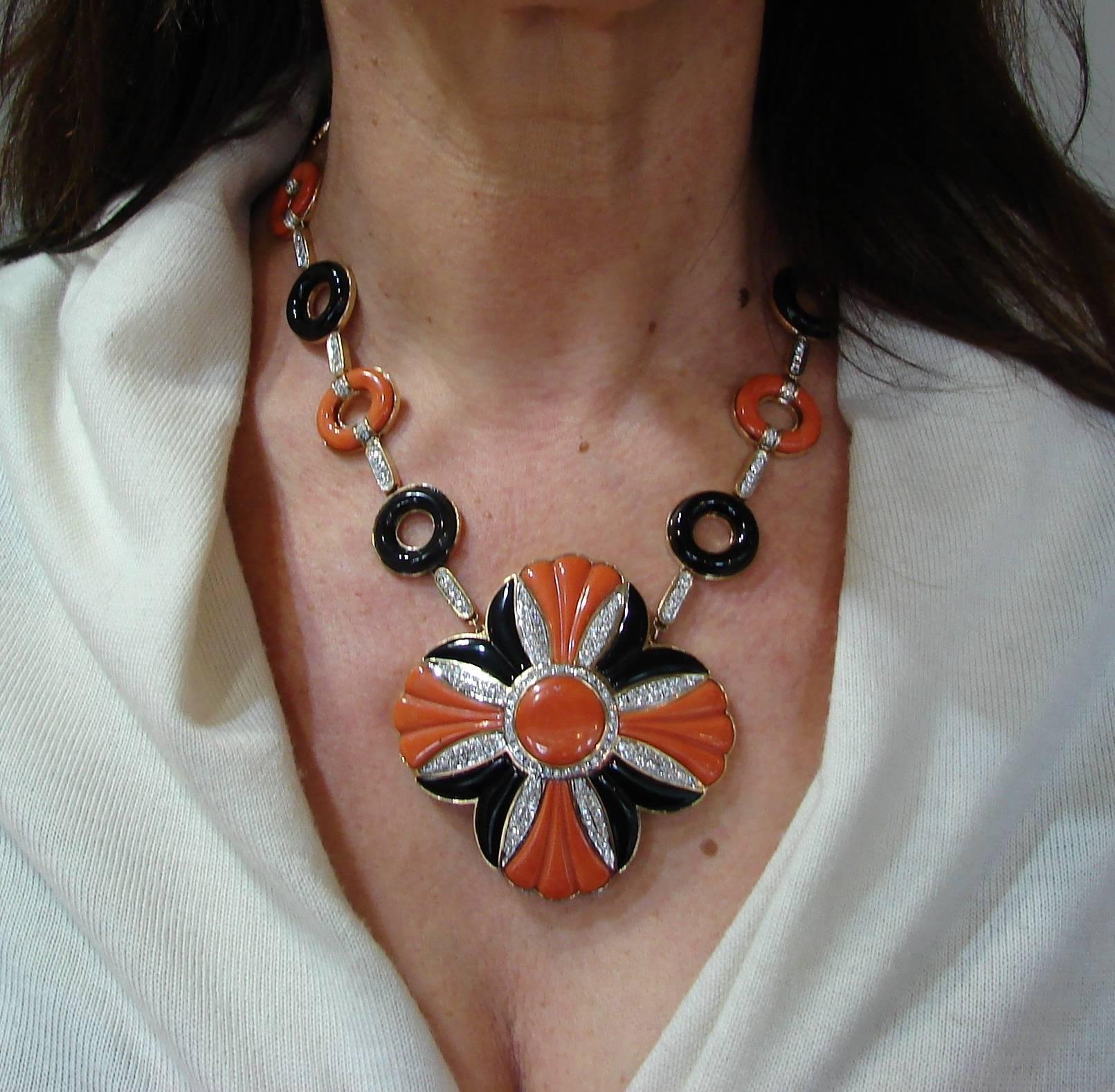 Bold, colorful necklace created in the 1970's. It definitely makes a statement. 
The necklace is made of 18 karat yellow gold, carved Mediterranean coral and black onyx and accented with round brilliant cut diamonds (G-H color, VS clarity, total