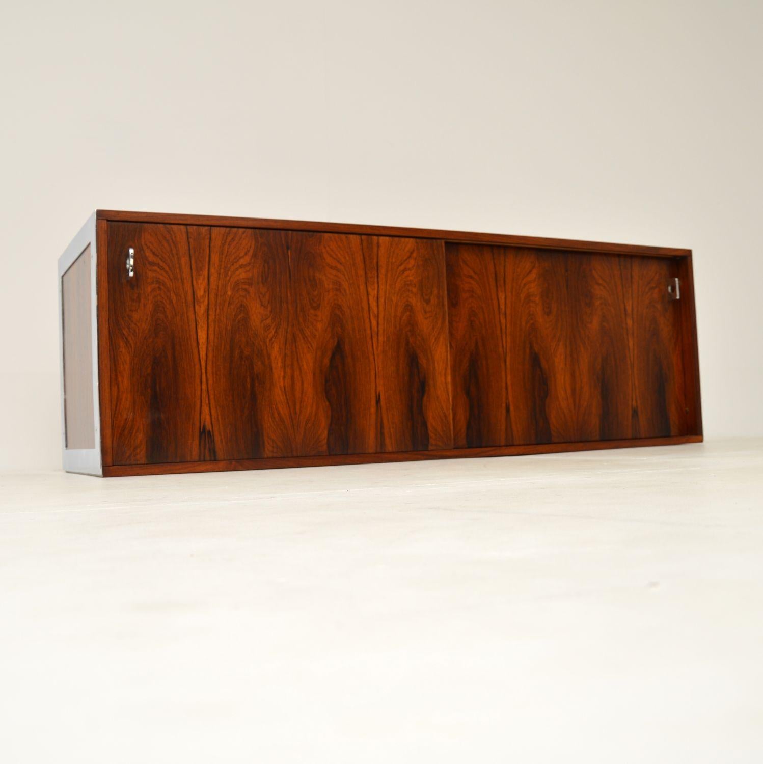 A stunning and extremely rare wall mounting sideboard in wood and chrome. This was designed by Richard Young, it was made by Merrow Associates in England and dates from the early 1970’s.

The quality is absolutely superb, with incredibly fine