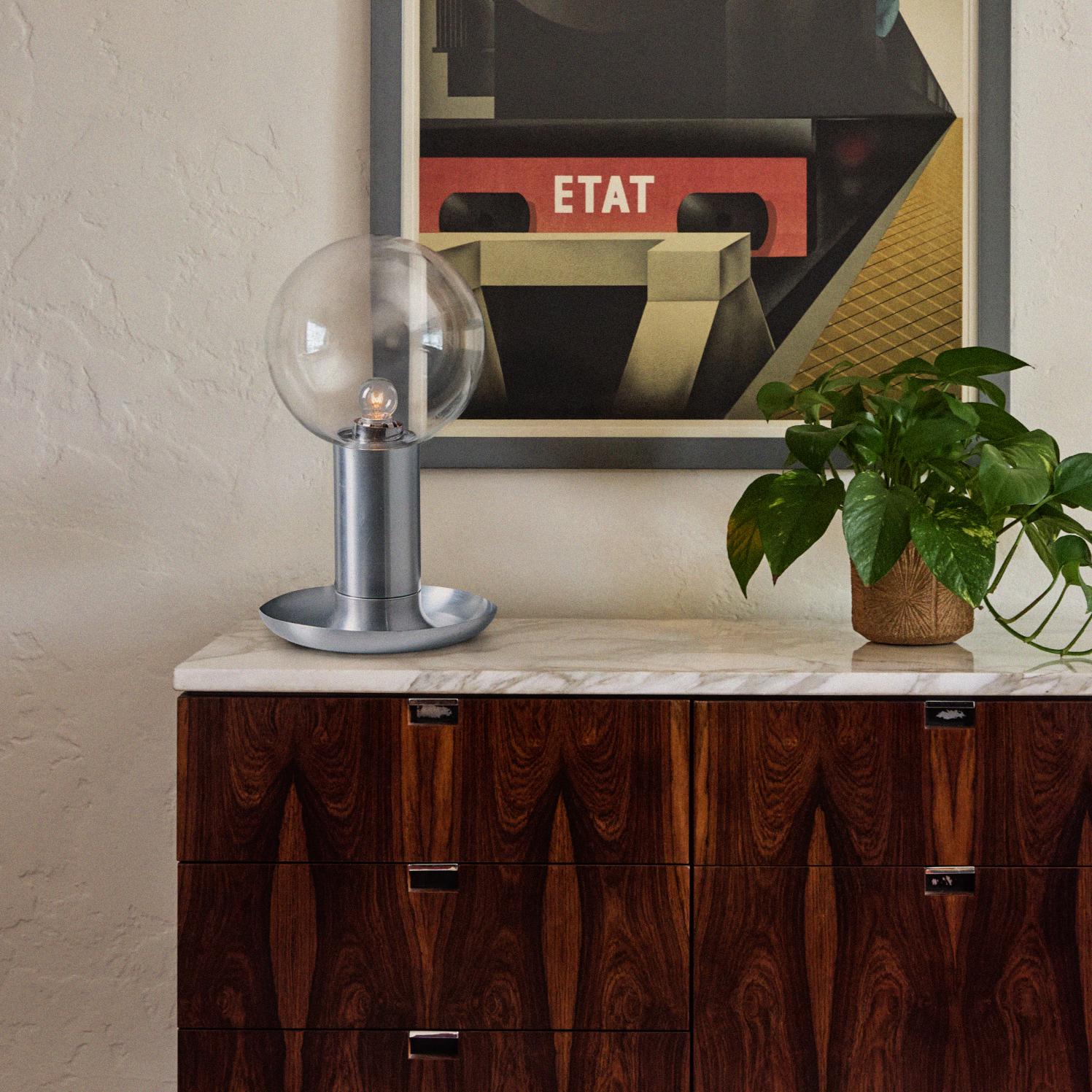 Lampe de table en métal et verre des années 1970 à la manière d'Achille Castiglioni.

Exécutée en aluminium filé avec un abat-jour transparent, cette lampe de table évoque la quintessence des designs minimalistes des icônes de l'éclairage italien