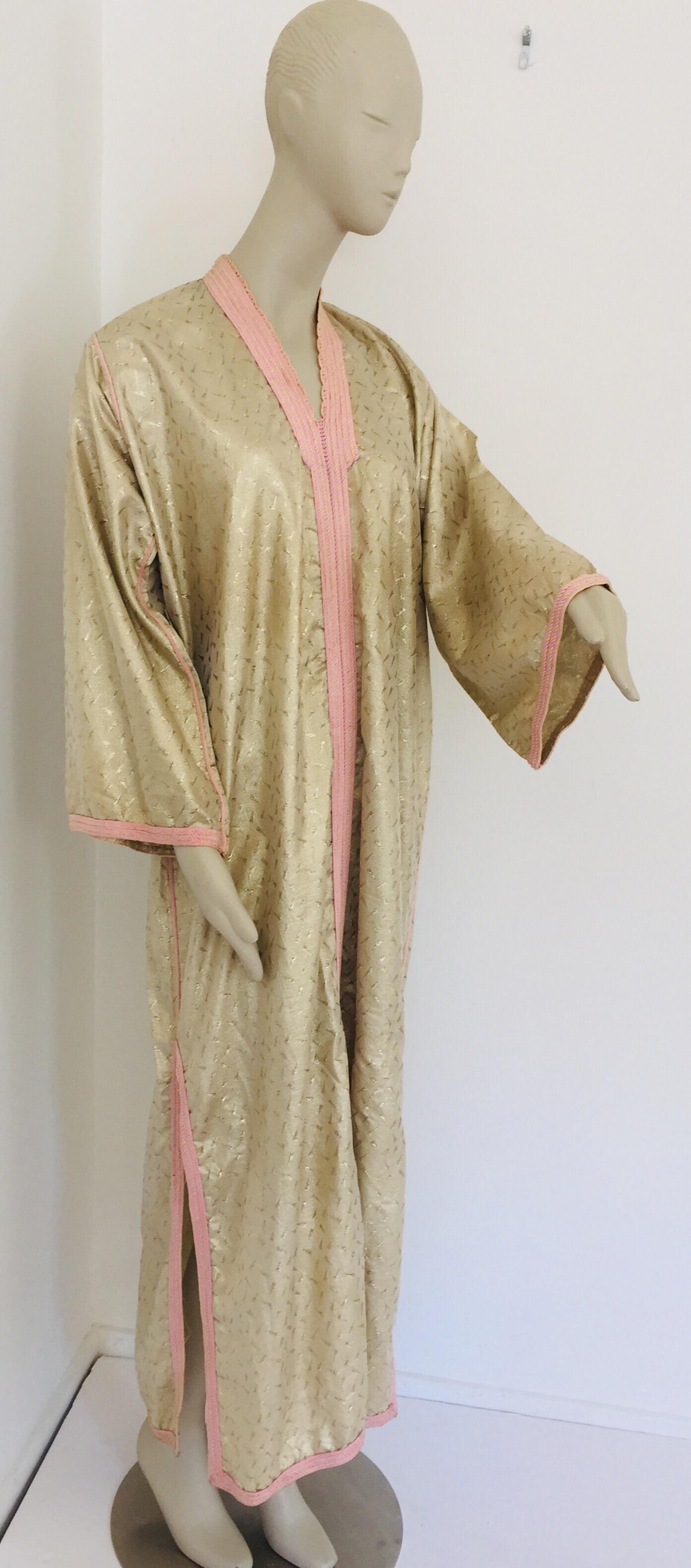 Moroccan evening or interior gold metallic brocade dress kaftan with pink trim.
Handmade vintage exotic, 1970s metallic brocade caftan gown from North Africa, Morocco.
The luminous gold metallic Moroccan caftan maxi dress is made in a subtle
