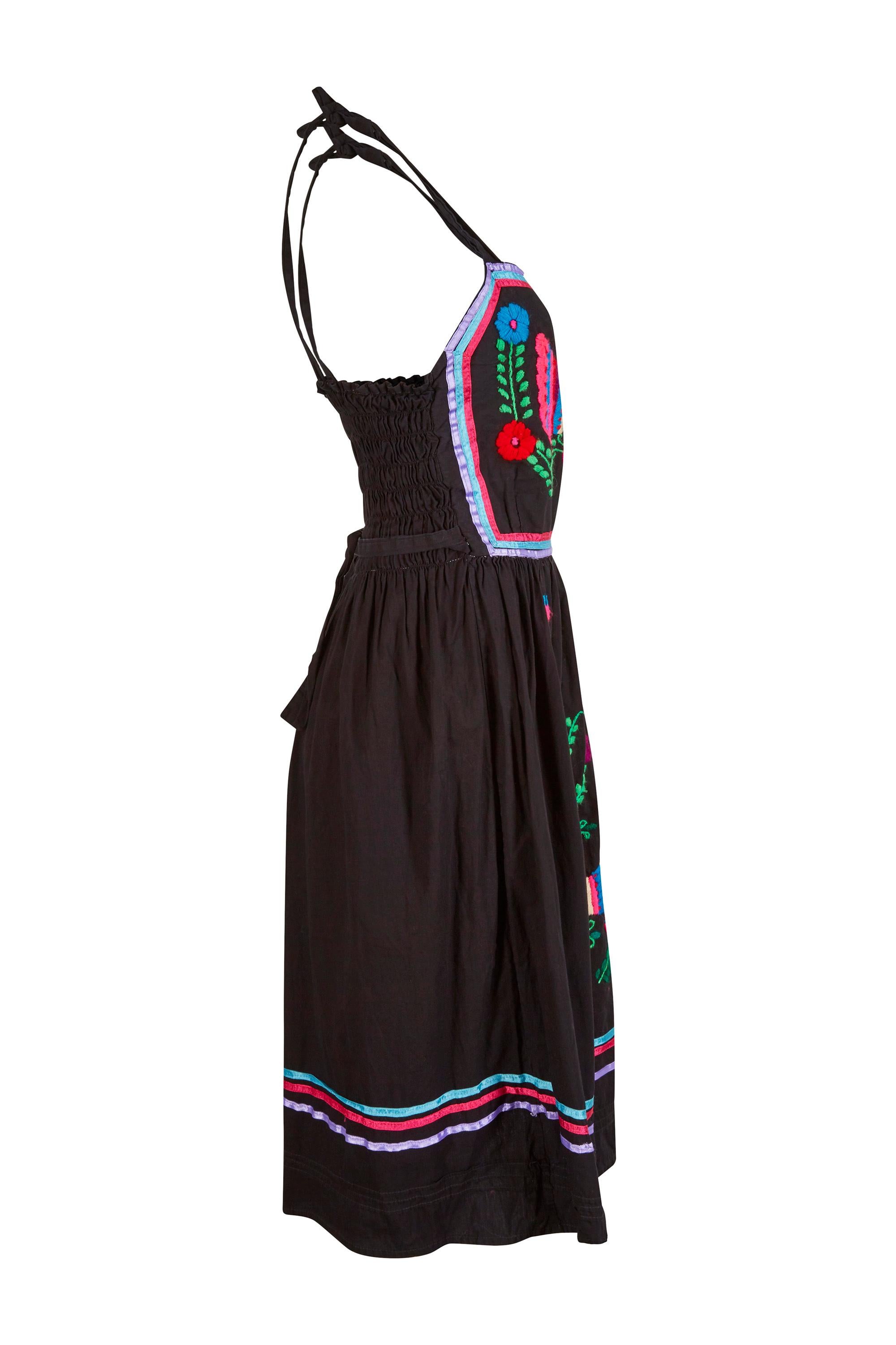 This wonderful 1970s black cotton sundress with colourful hand embroidery is a beautiful example of the Mexicana style popular in the 60s and 70s and is an American label emulating the traditional Mexican Huipil dress to perfection. The thick cotton