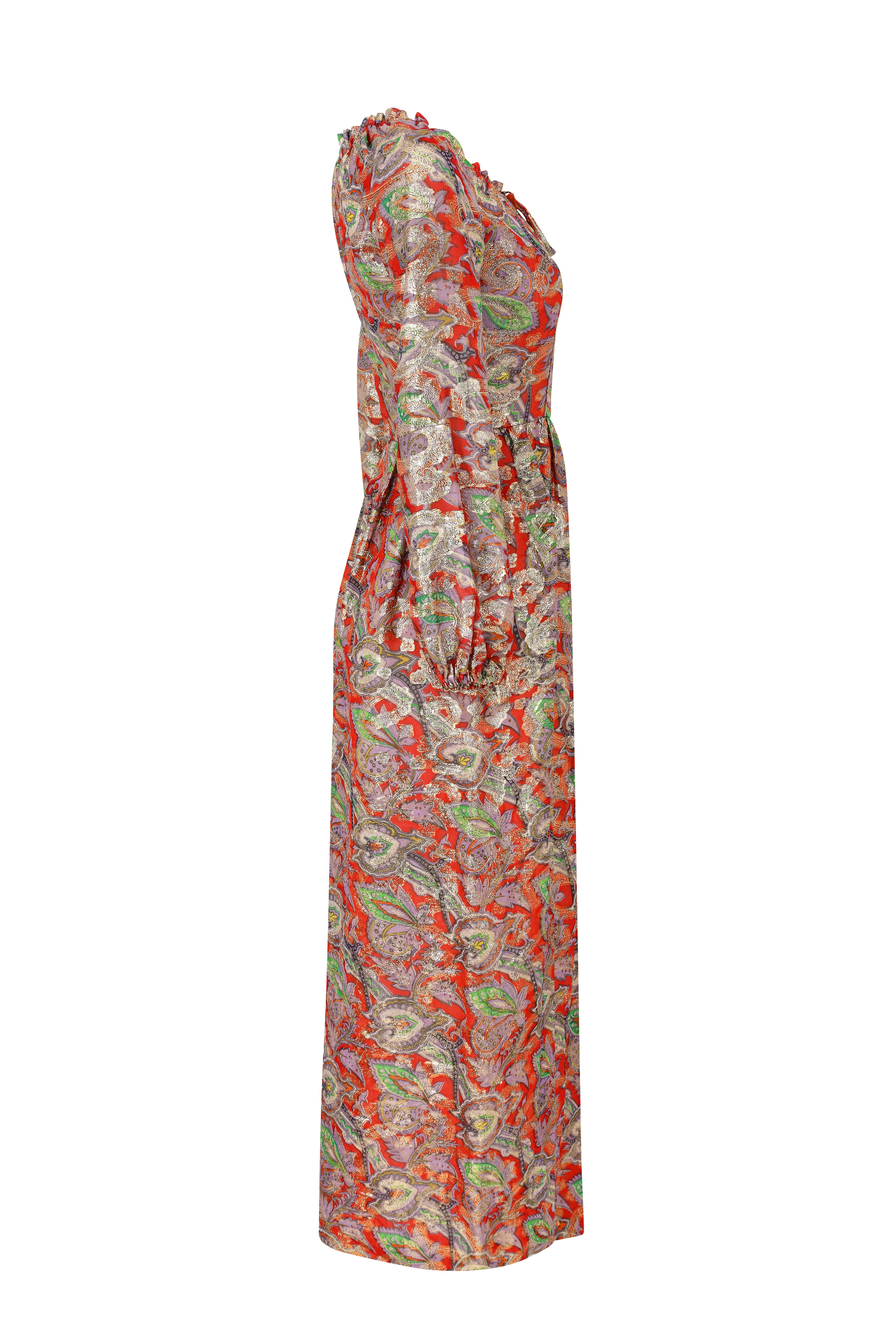 This sensational 1970s lamé paisley print maxi dress in gold, red, lilac and green is labelled Michael Modelle and is in excellent vintage condition. It has an opulent, bohemian aesthetic. The dress has a a gathered round neckline with draw string