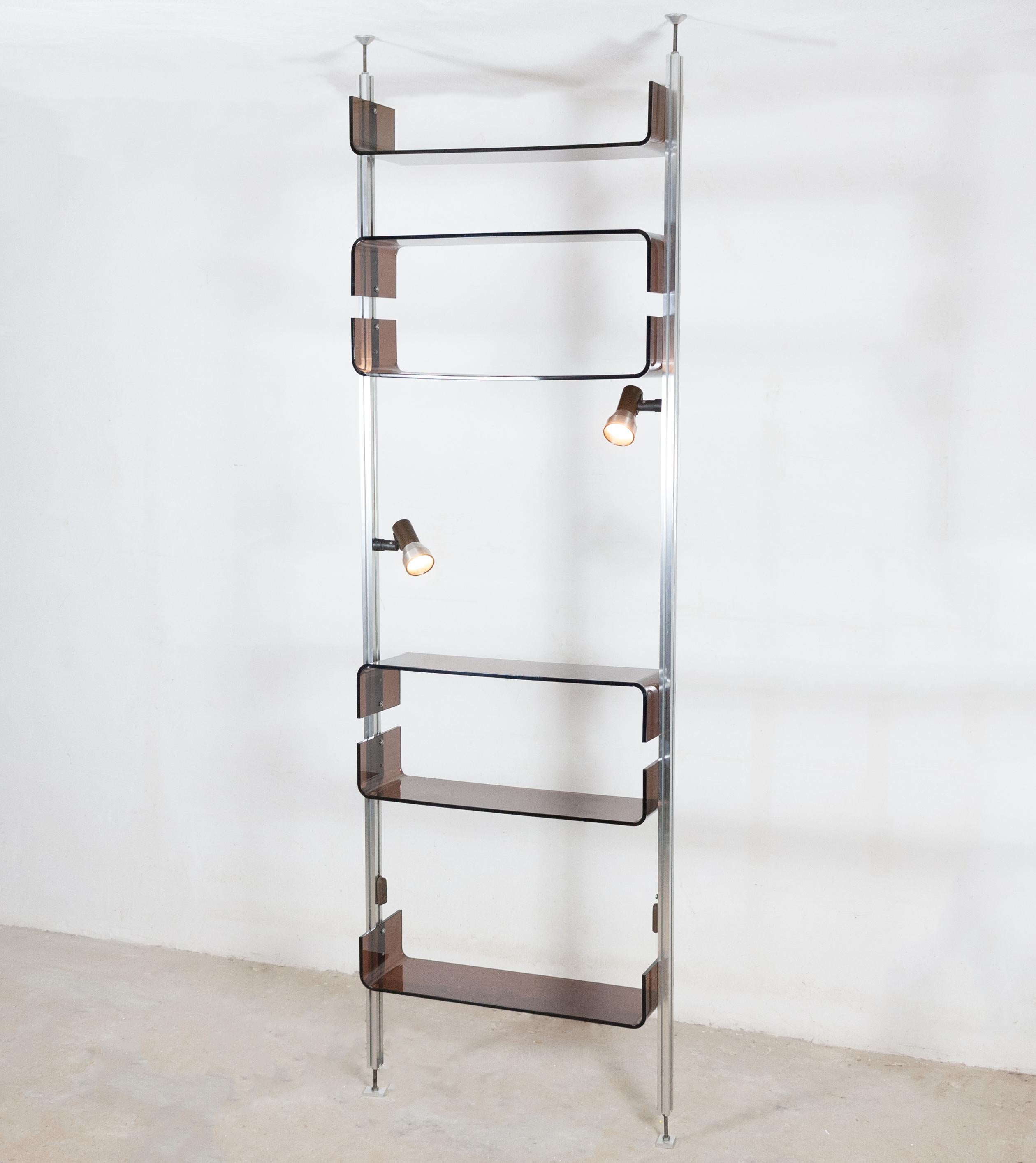 Beautiful shelving unit designed by Michel Ducaroy for the French designer furniture company Roche Bobois in 1970. 

The unit consists of six Lucite shelves and two integrated spotlights which attach to a pair of metal uprights clamped between floor
