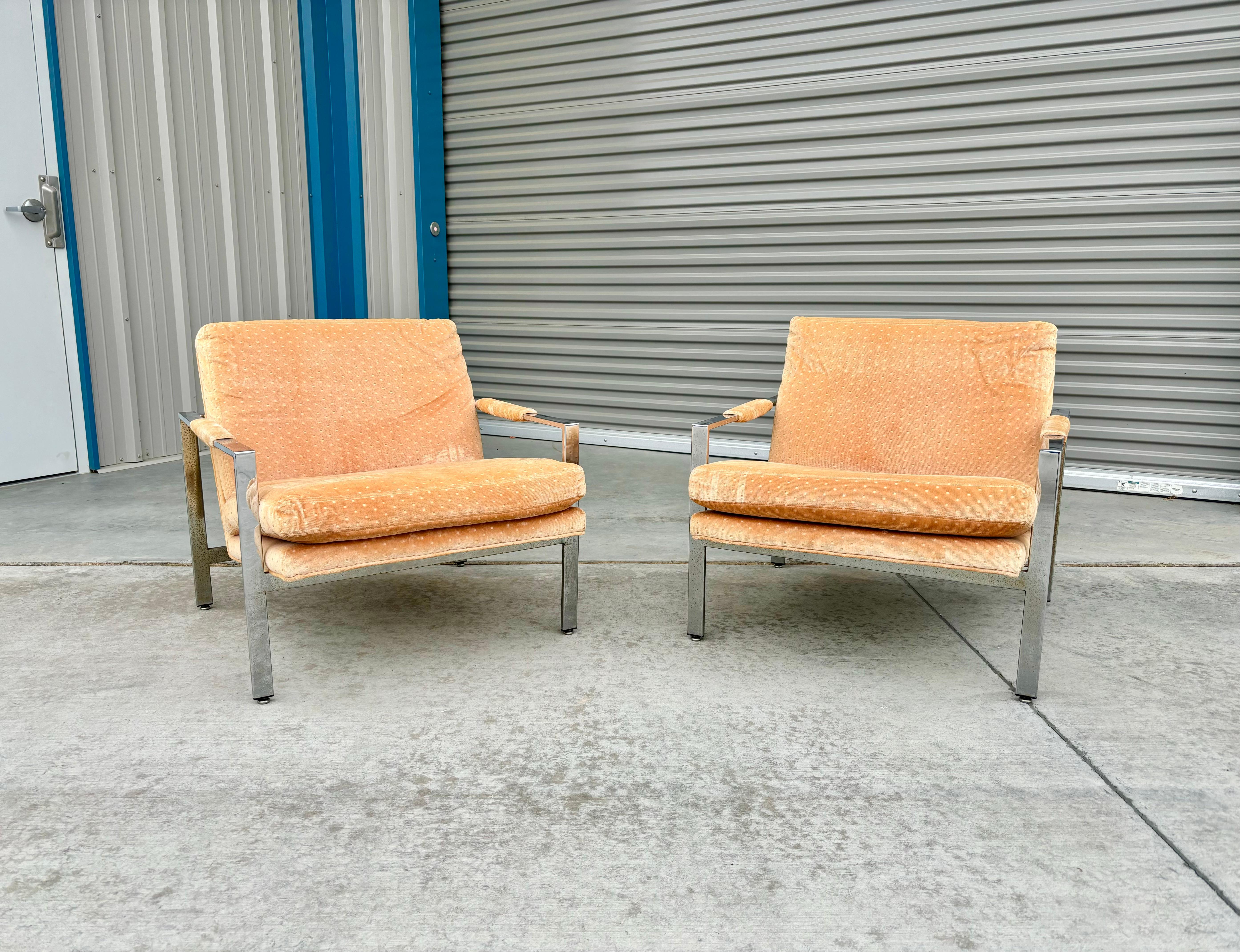 Mid-century chrome lounge chairs designed by Milo Baughman and manufactured by Thayer Coggin in the United States circa 1970s. The sleek chrome frames elegantly support the vibrant orange upholstery, offering a perfect blend of form and function.