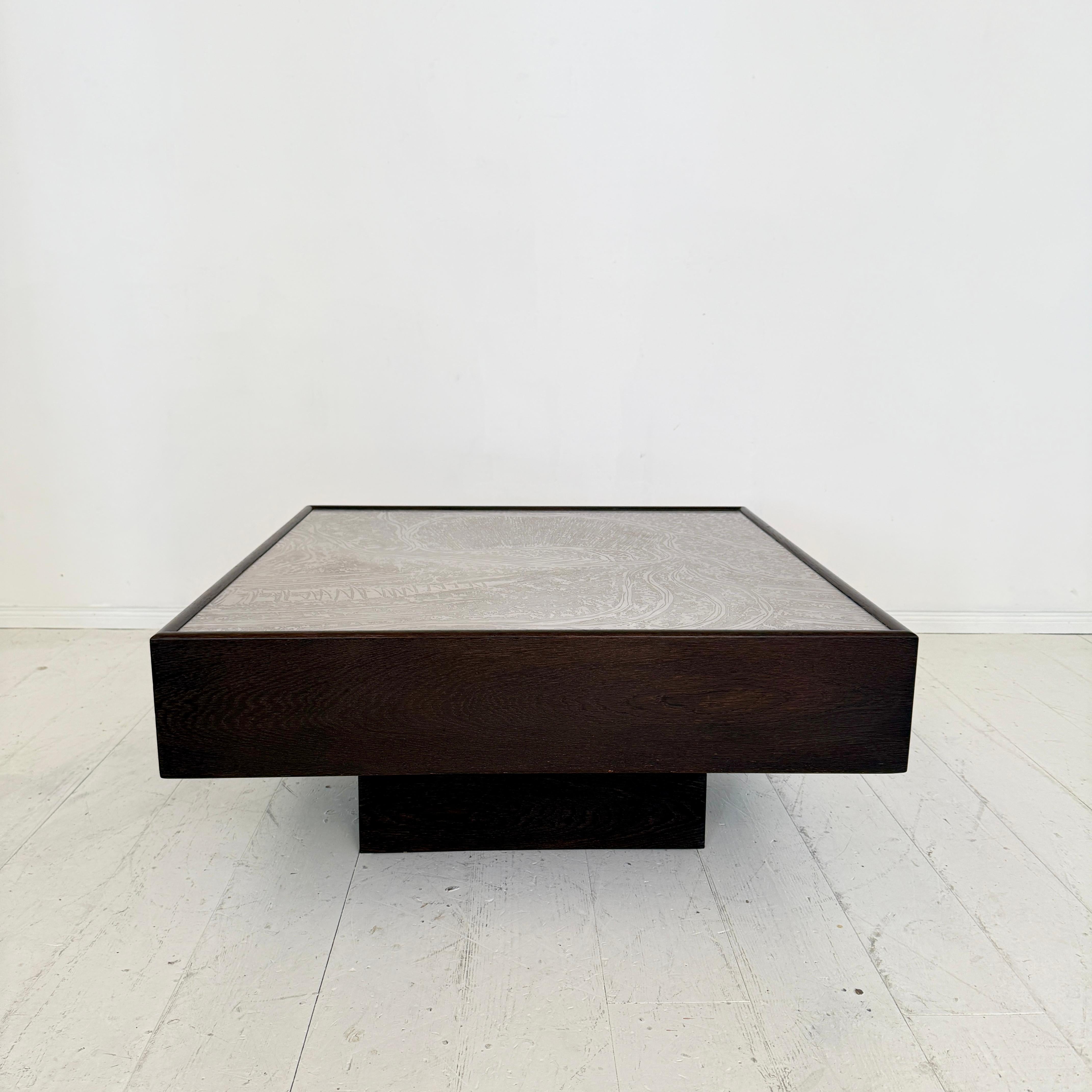A striking Mid-Century Modern coffee table designed by Lilienthal in the 1970s, combining sculptural form with refined materials. The table is crafted from dark brown oak, showcasing a deep, rich grain that emphasizes its geometric silhouette.