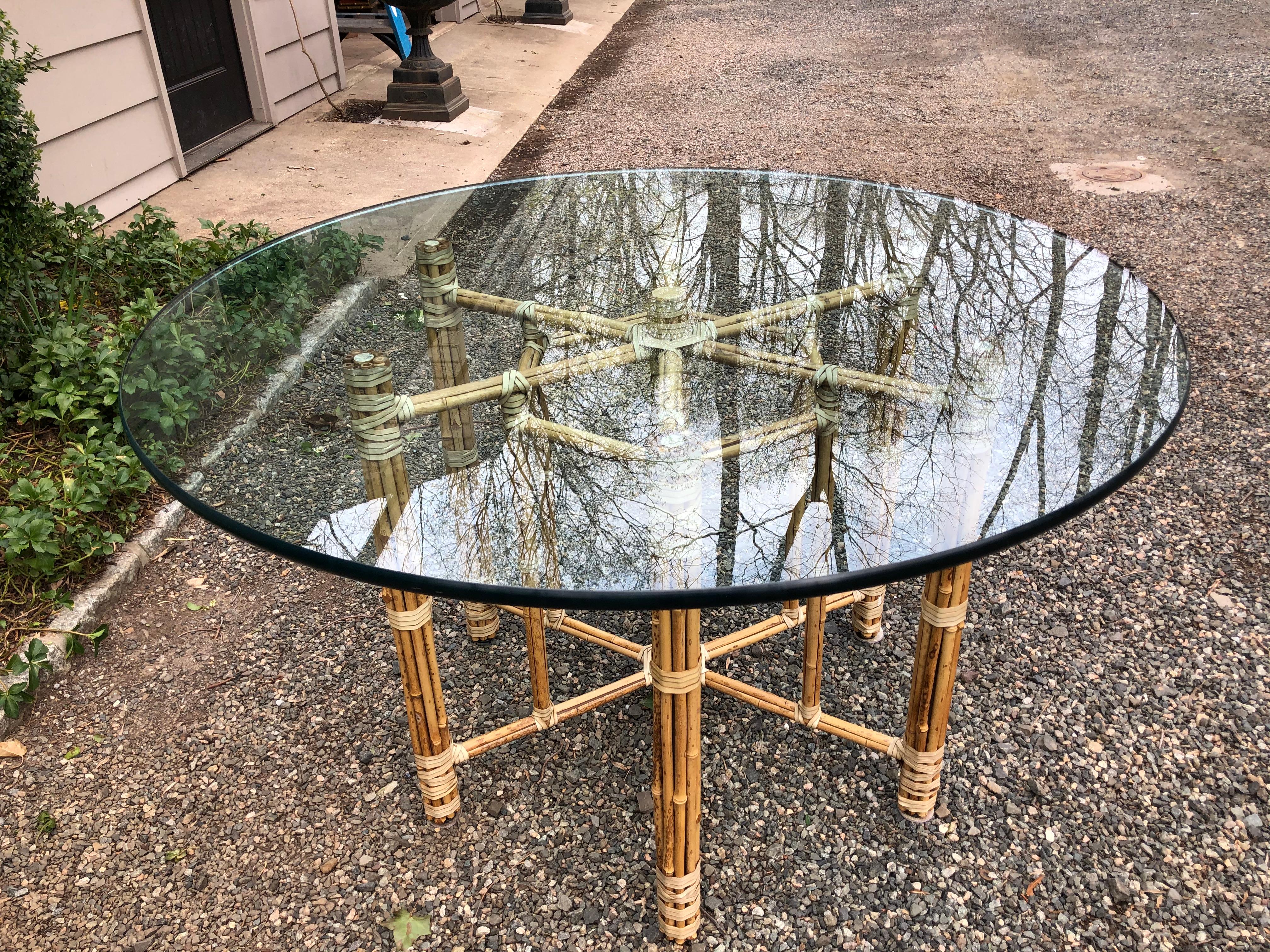 An octagonal bamboo rattan dining or breakfast table made in the California organic modern style by McGuire. The table features an iron frame that is completely wrapped with bamboo poles. The bamboo is fastened together with leather rawhide laces.