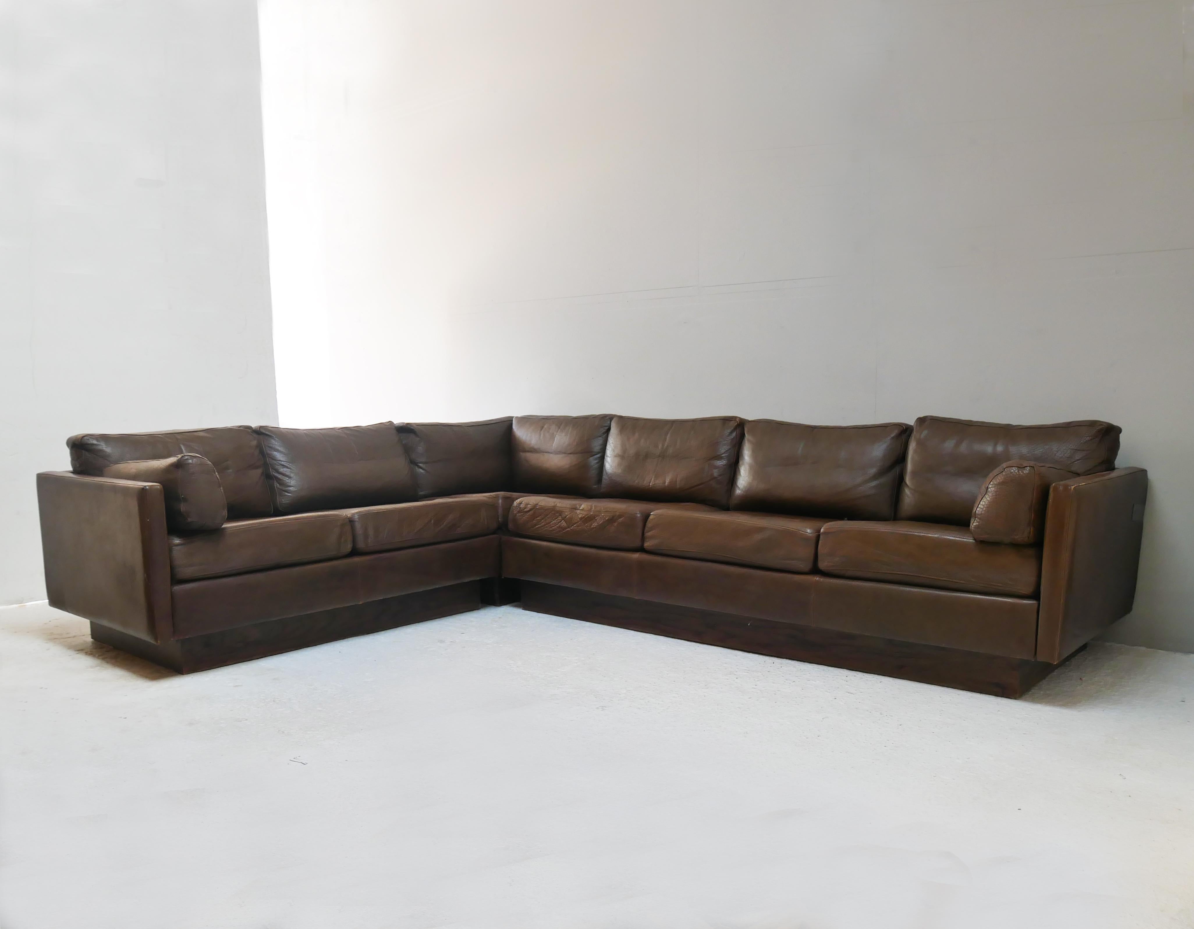 A Mid-Century Modern sectional sofa made in the early 1970’s in Denmark.
Upholstered in the original thick brown leather which is in great condition. Sits on wooden plinth base. All cushioning in great condition. Extremely comfortable.

Overall