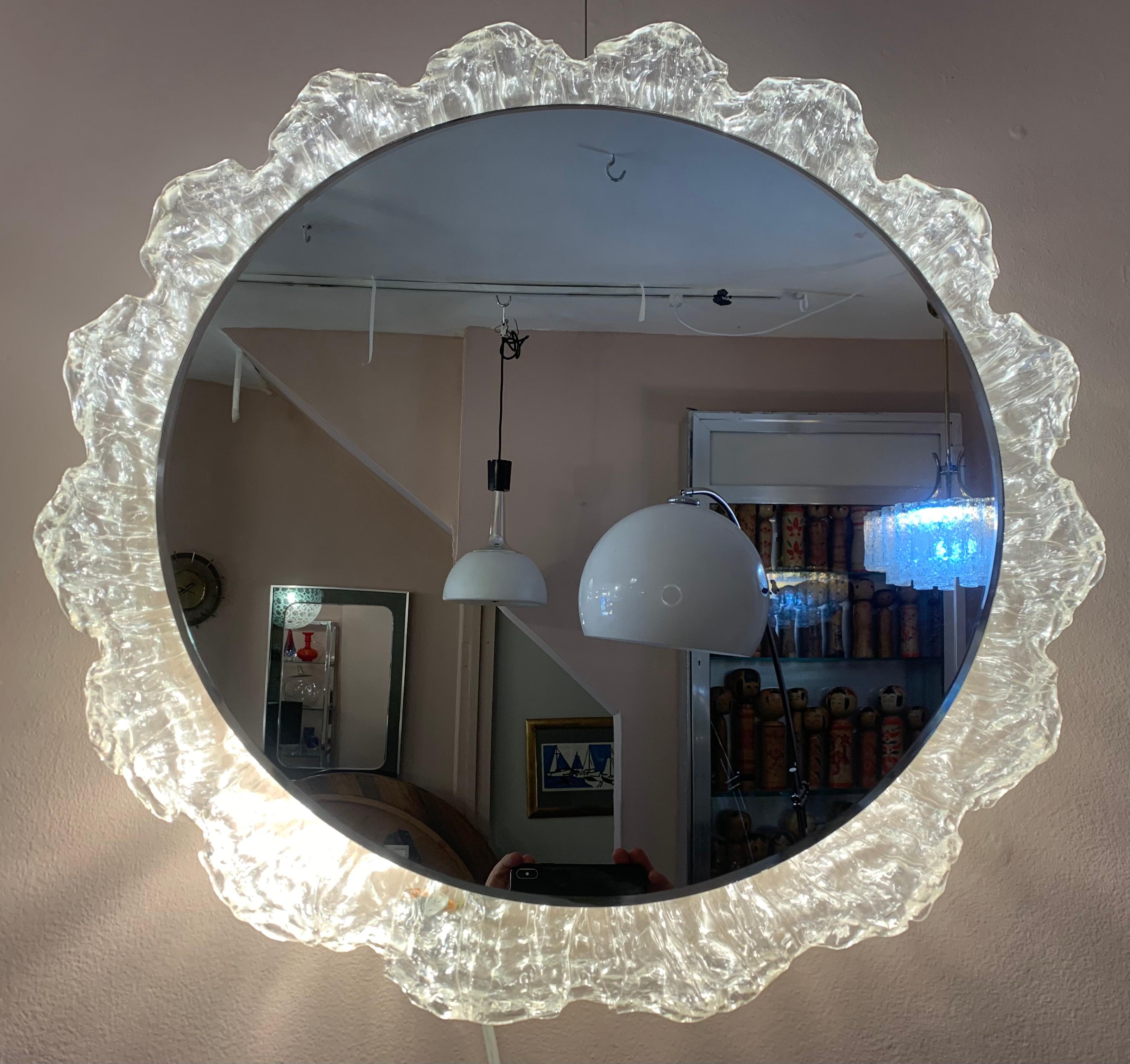 1970s German illuminated wall mirror with a large sunflower design made from mottled lucite/acrylic which the mirror sits within. The mirror hooks onto the frame which the four bulbs sit behind. The frame is easily screwed onto the wall. To change