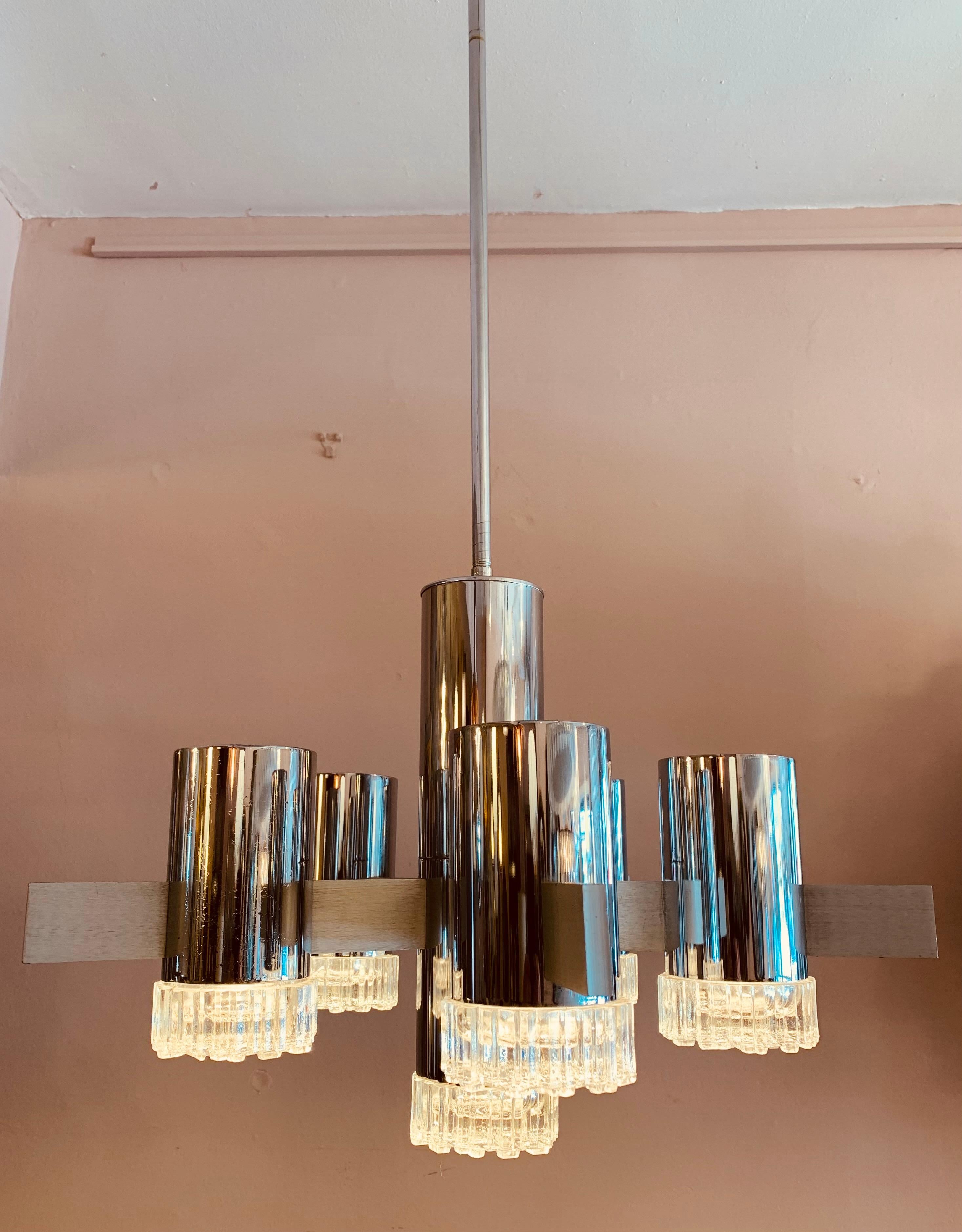 An unusual and abstract ceiling light designed by Gaetano Sciolari for Sciolari. Polished vertical chrome metal tubes house each bulb which are capped at the bottom by a moulded geometric patterned glass light diffuser. Each tube is supported by