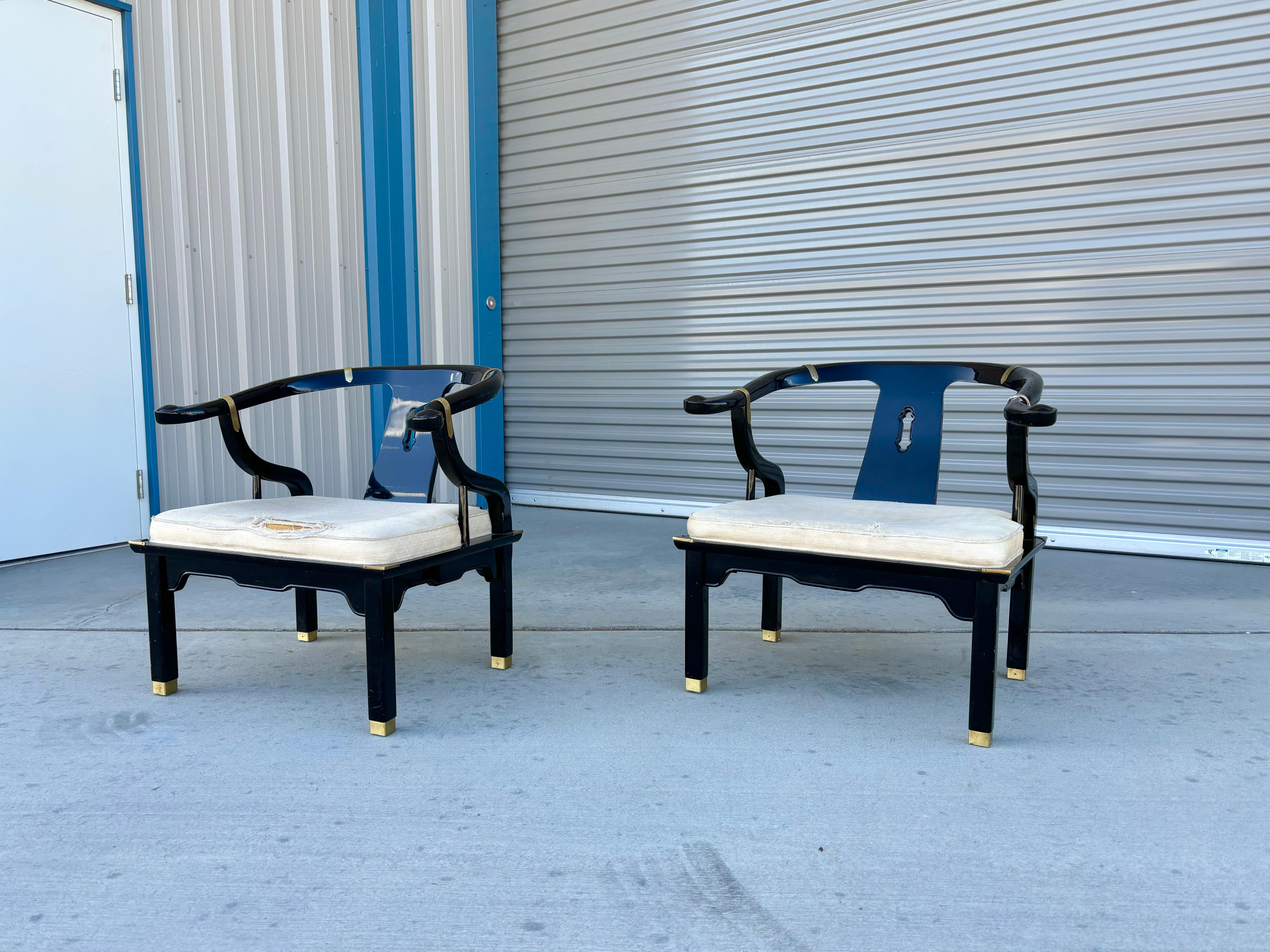 Mid-century lounge chairs styled after James Mont and manufactured by Century Furniture in the United States circa 1970s. The sleek black lacquered frame is perfectly complemented by the elegant brass fittings, which lend a touch of sophistication