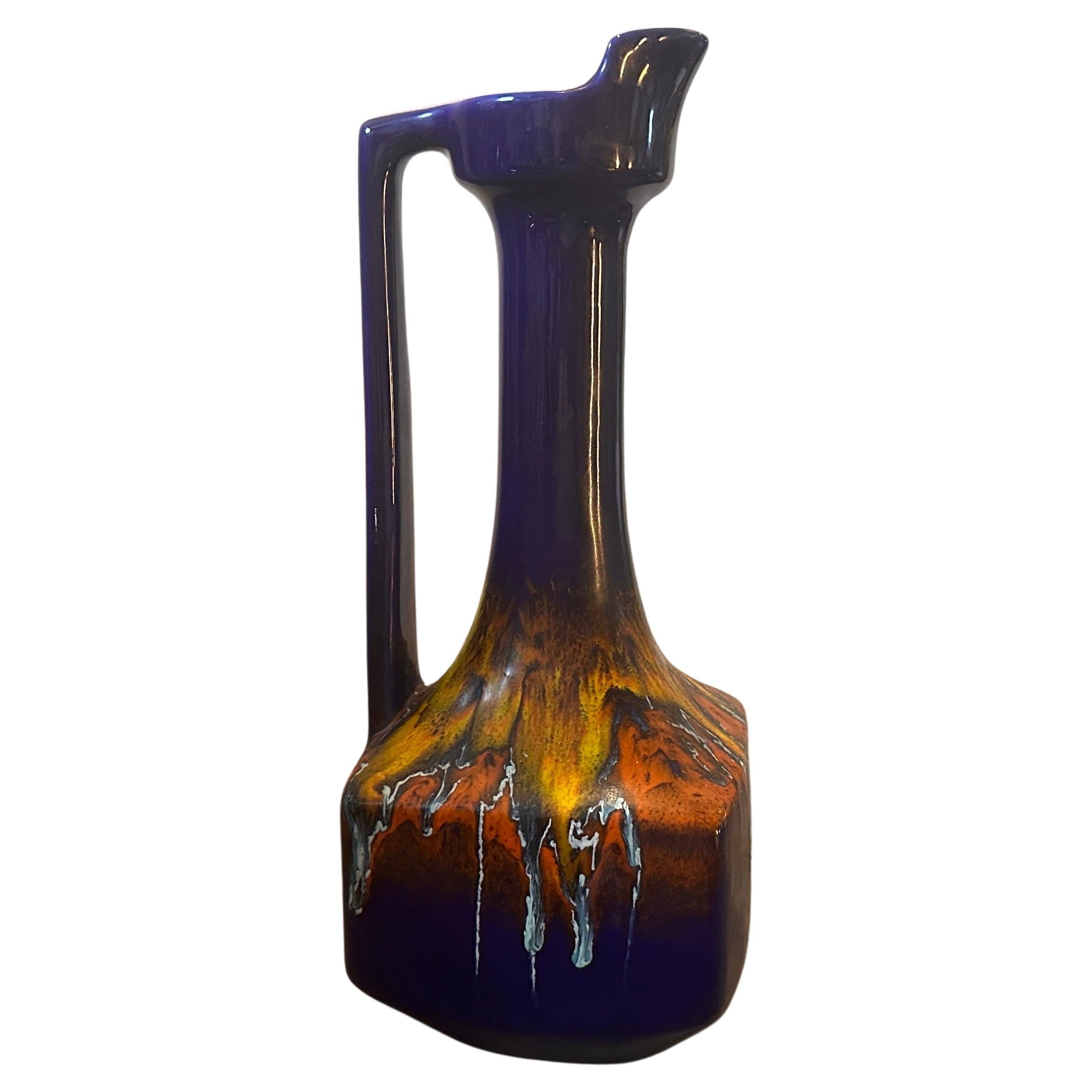 Ce vase à carafe conçu et fabriqué par Bertoncello est une pièce d'art et de design visuellement captivante et historiquement significative. Sa combinaison unique de formes, de couleurs et de savoir-faire incarne l'esprit du modernisme du milieu du