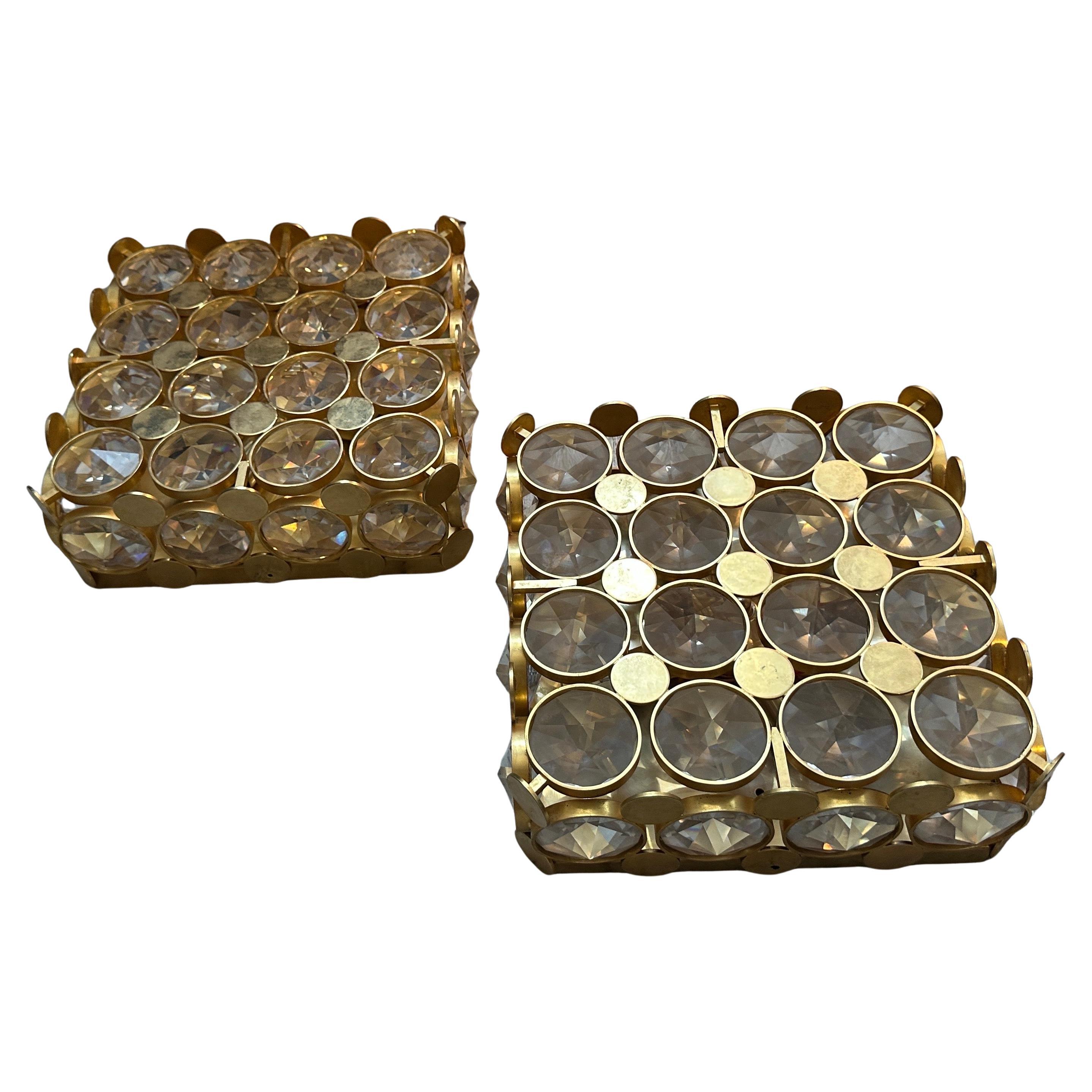 Un'affascinante coppia di sconsole da parete quadrate in ottone e vetro sfaccettato della modernità degli anni Settanta. Questi squisiti pezzi incarnano perfettamente l'estetica del Mid-Century Modern con un tocco decadente, mostrando un brillante