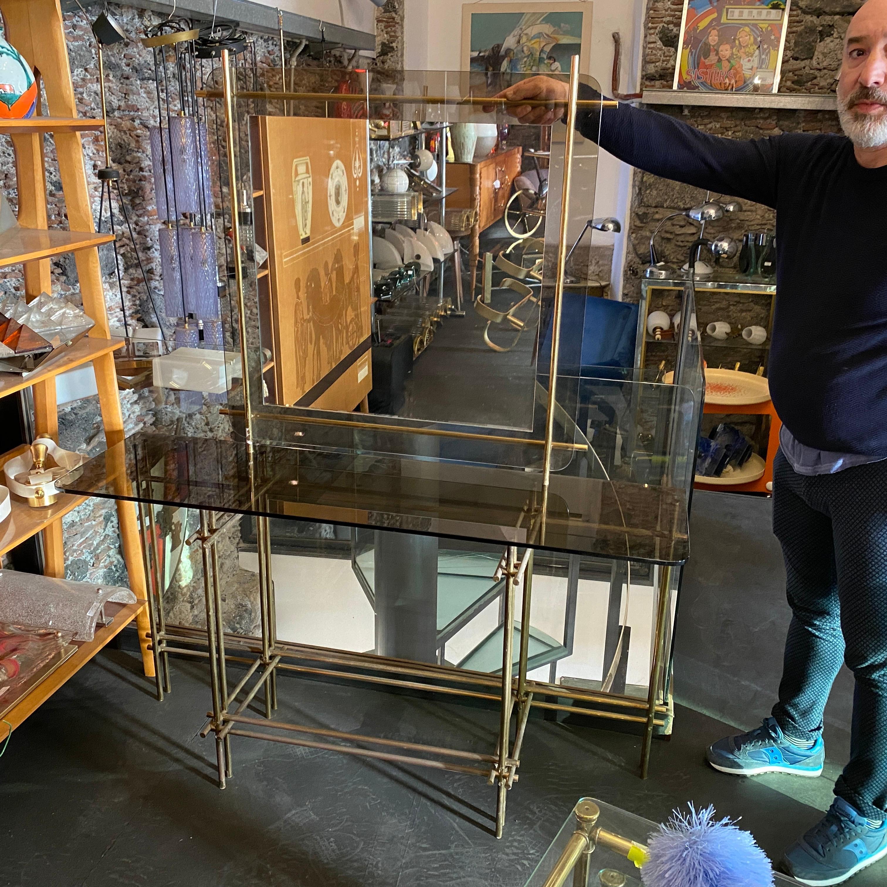 Stylish brass and smoked glass console made in Italy in the seventies, brass it's in original patina, glasses are in perfect conditions. It has his original squared mirror, dimensions of the mirror width cm 85, height cm 85, depth cm 3.