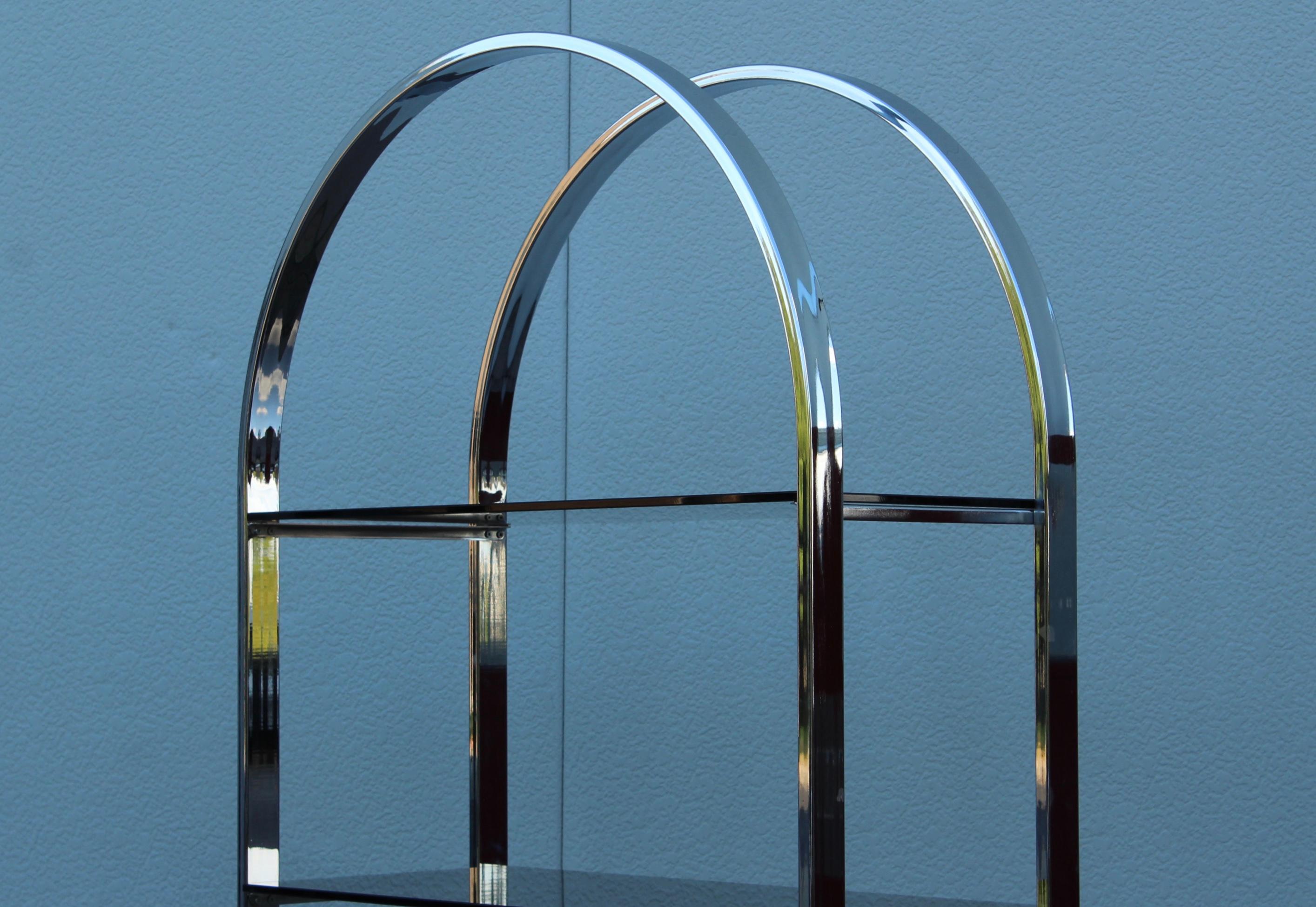 1970's Mid-Century Modern chrome with 4 glass shelves arch etagere, In vintage condition with minor wear and patina to the chrome due to age and use.