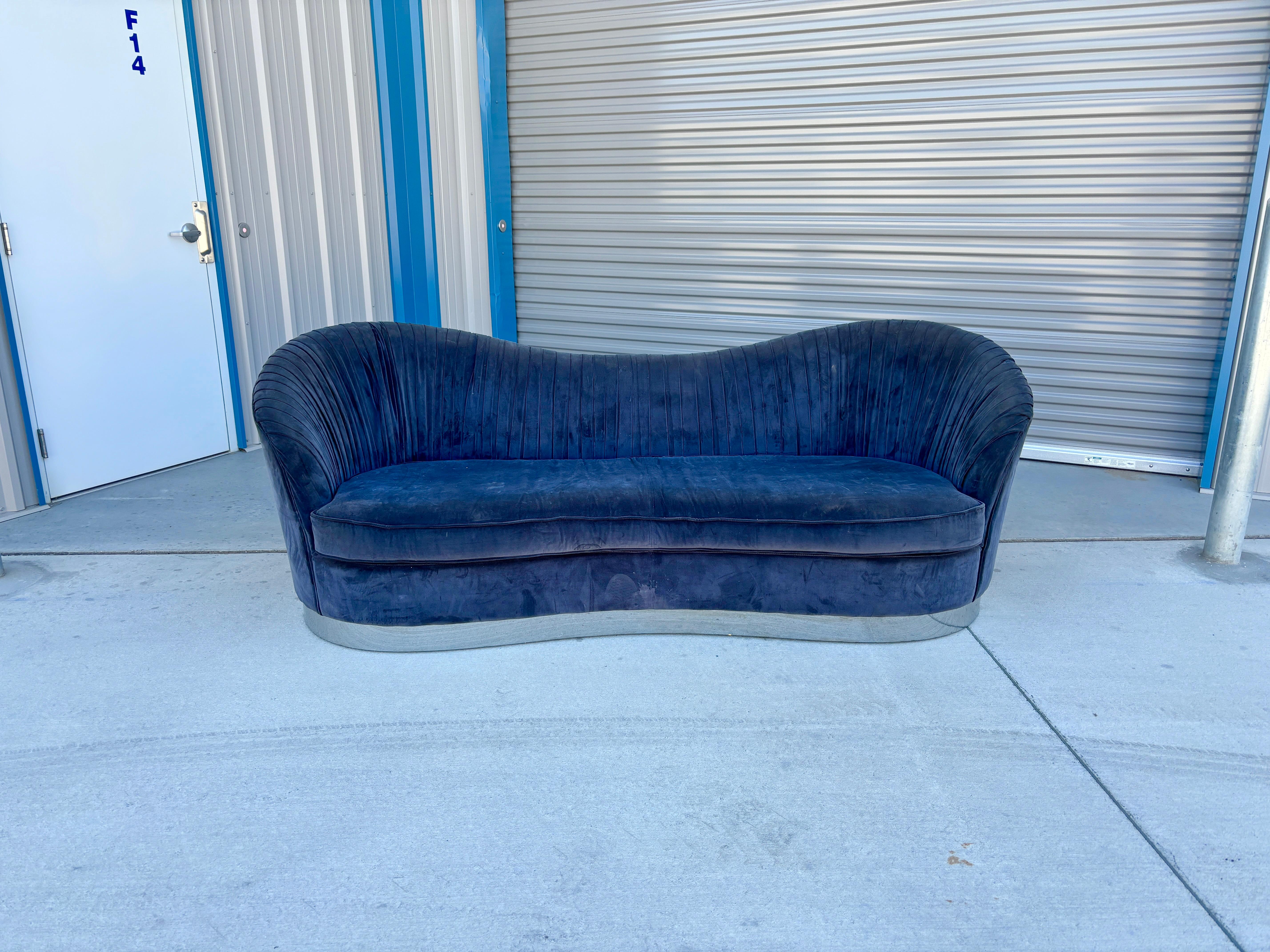 This mid-century modern velvet and chrome sofa was designed and manufactured in the United States circa 1960s. This stunning velvet and chrome sofa boasts a magnificent blue velvet upholstery that sits elegantly on a chrome base, creating an