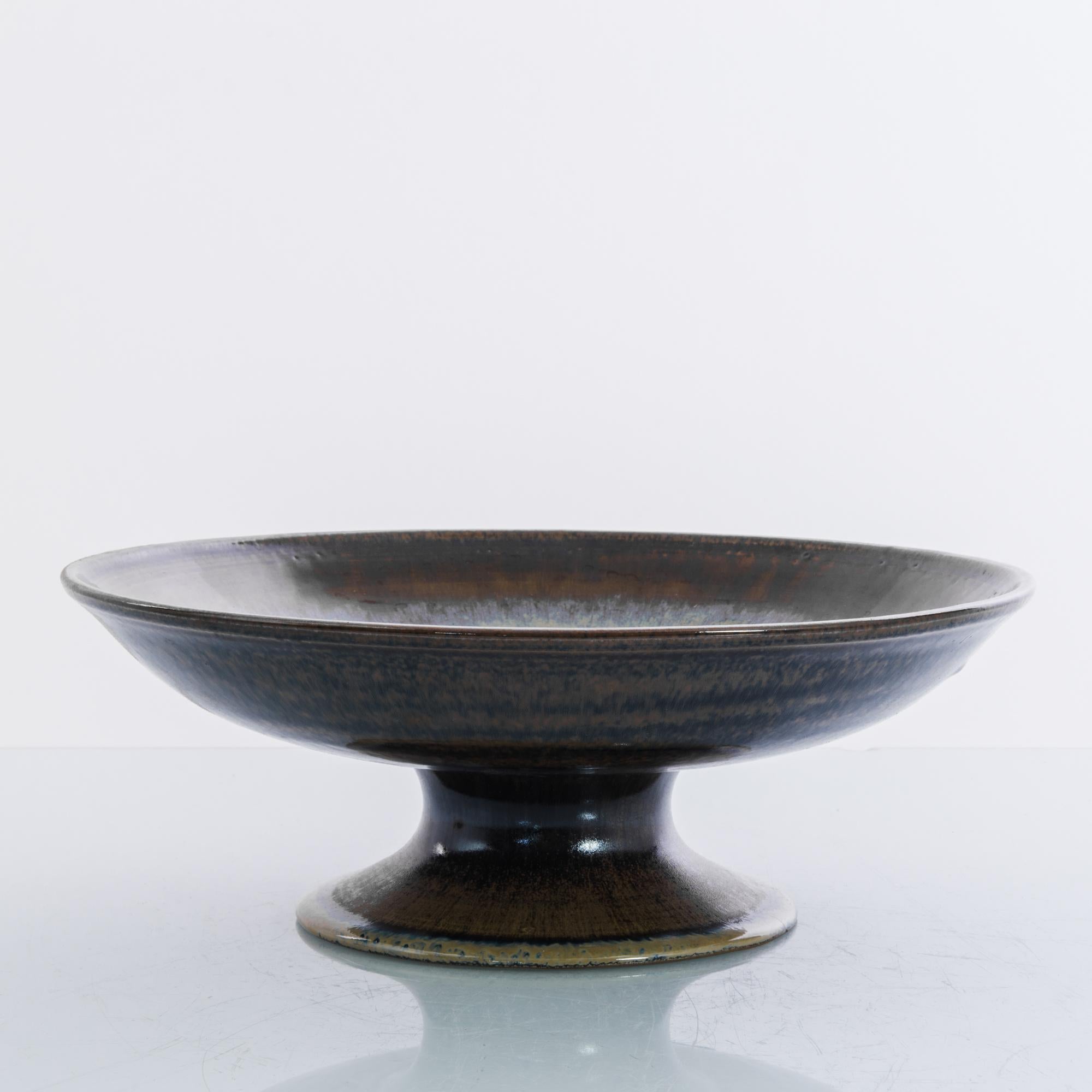 A ceramic fruit bowl from Europe, circa 1970. This decorative bowl is dressed in soothing earth tones. High quality stoneware, with distinctive color schemes, graphic patterns and textures, this characteristic mid-century fashion expanded the