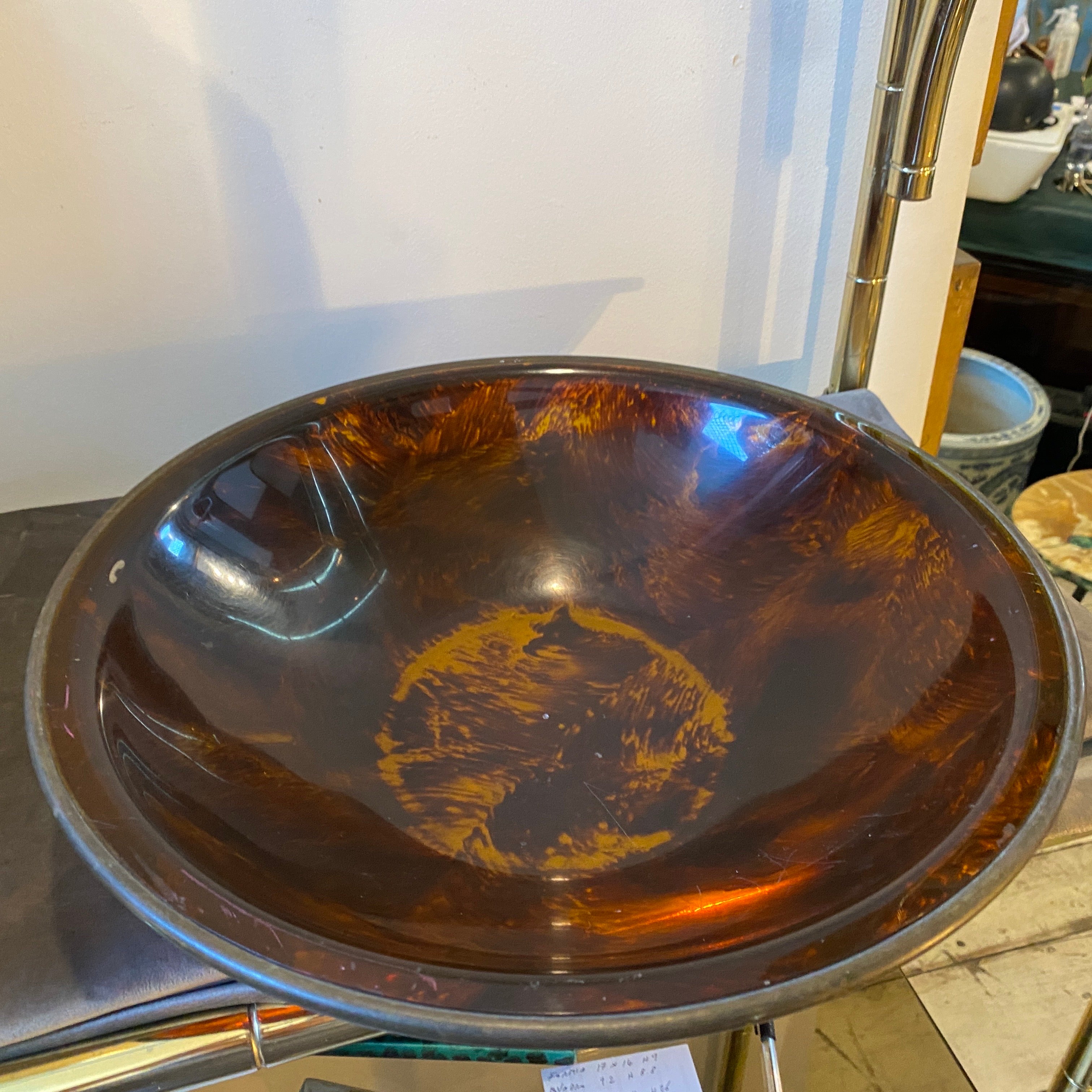 A Mid-Century Modern fake tortoise lucite and brass round bowl designed and manufactured in Italy in the style of Gabriella Crespi. Brass in original patina gives it a vibrant vintage look. The 1970s was a time of experimentation and innovation in