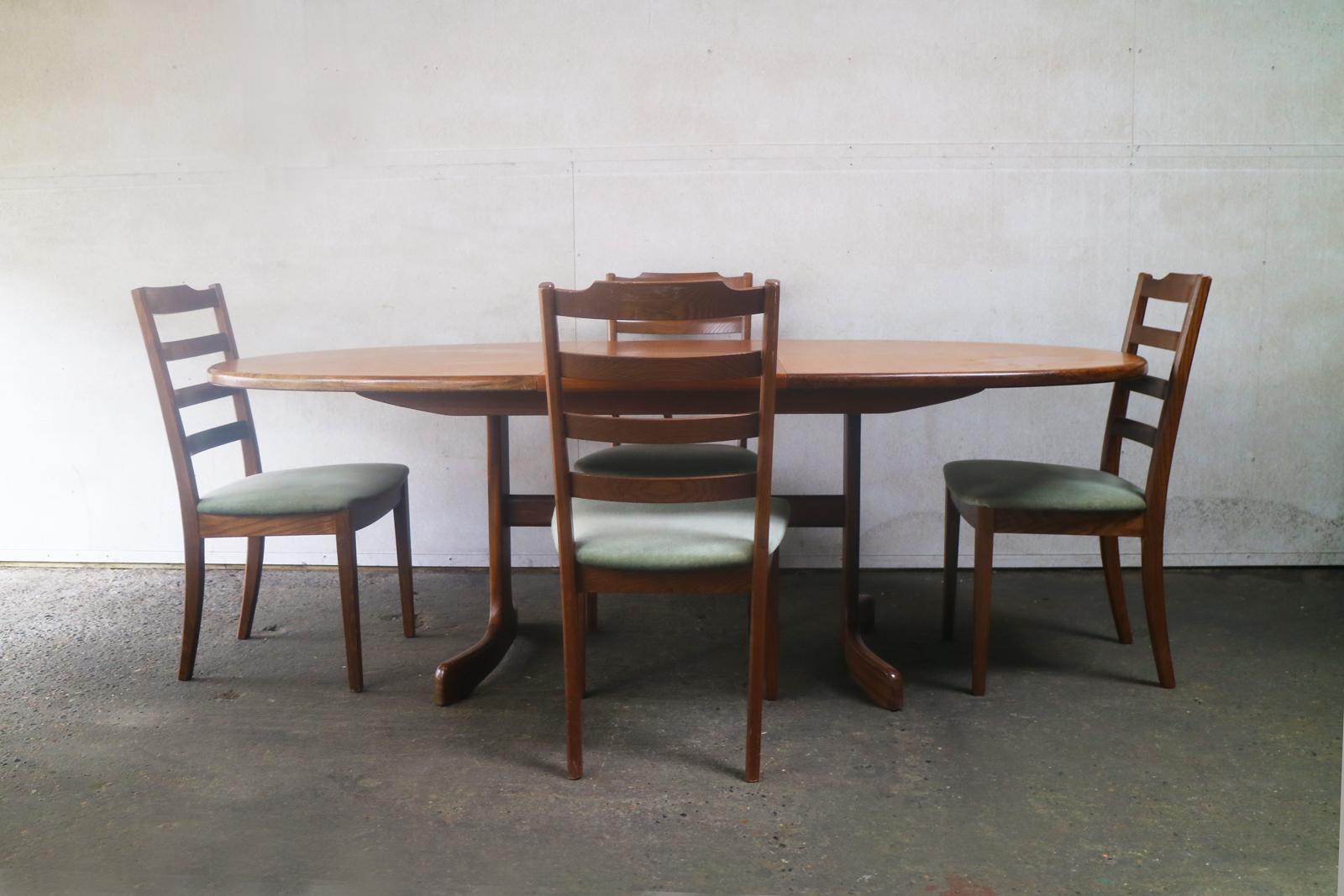 A large G plan extending ellipse shaped teak dining table with a matching, very elegant set G plan dining chairs upholstered in the original light green velour fabric. 

The dining table has a lovely smooth elliptical shape with light teak finish,