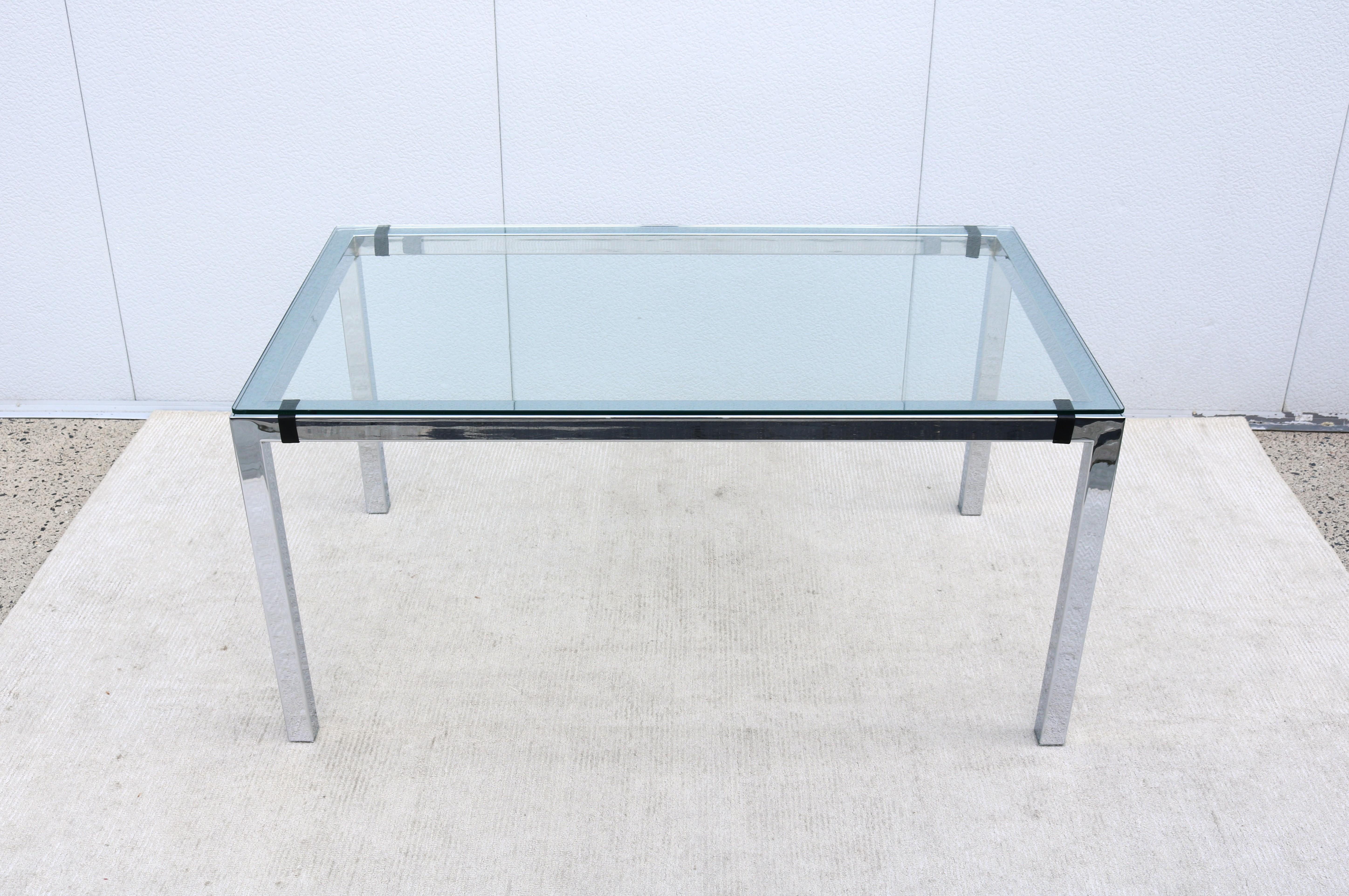 Fabuleuse table de salle à manger rectangulaire en verre trempé clair et acier chromé poli de style Milo Baughman, vintage des années 1970, par Tri-Mark Designs.
Quatre sangles en cuir noir protègent le plateau en verre contre le contact avec la