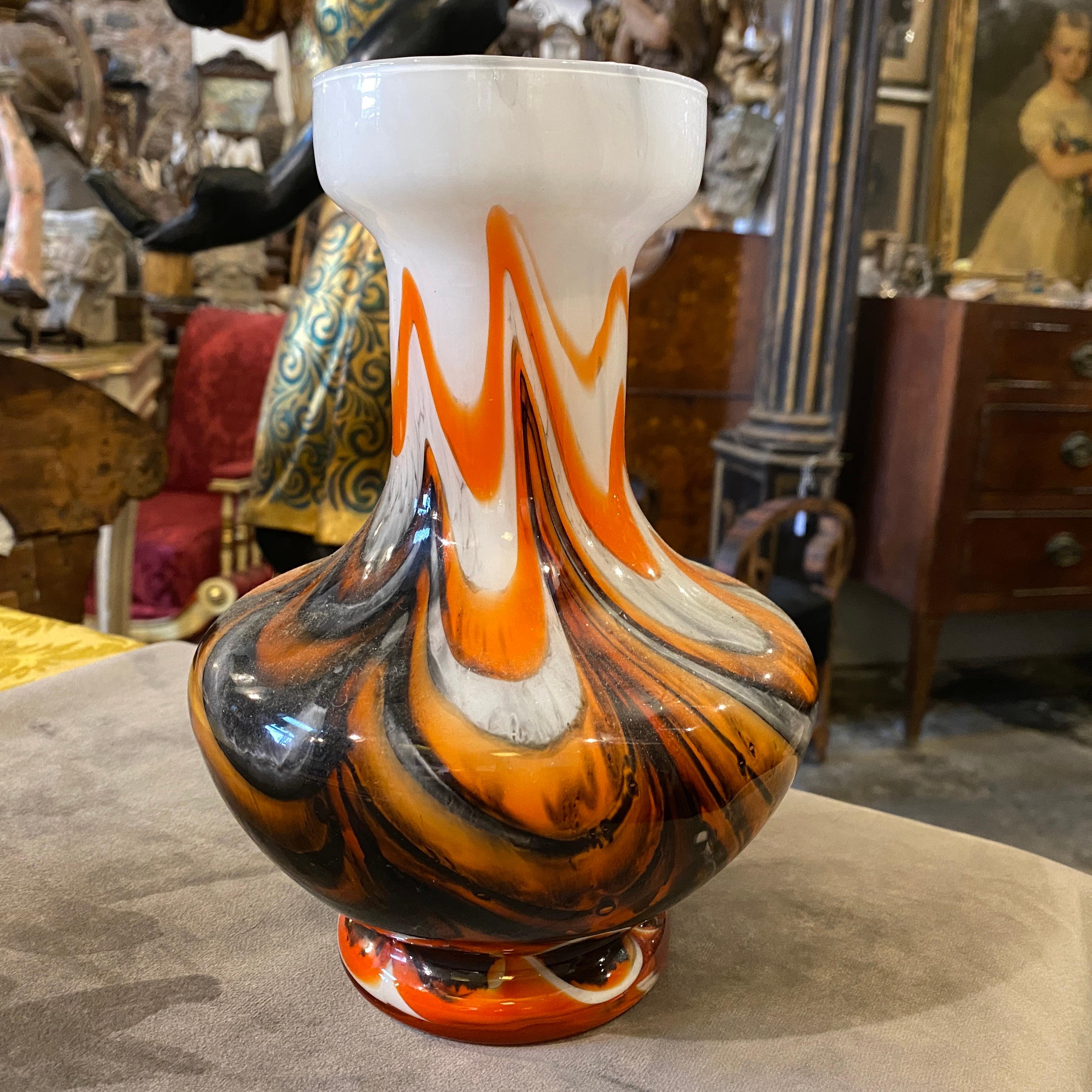 An opaline glass vase made in Italy in the Seventies. Orange and gray colors are typical of the period. It's in perfect conditions.
This captivating glass vase, designed by Carlo Moretti in the 1970s, epitomizes the essence of Mid-Century Modern