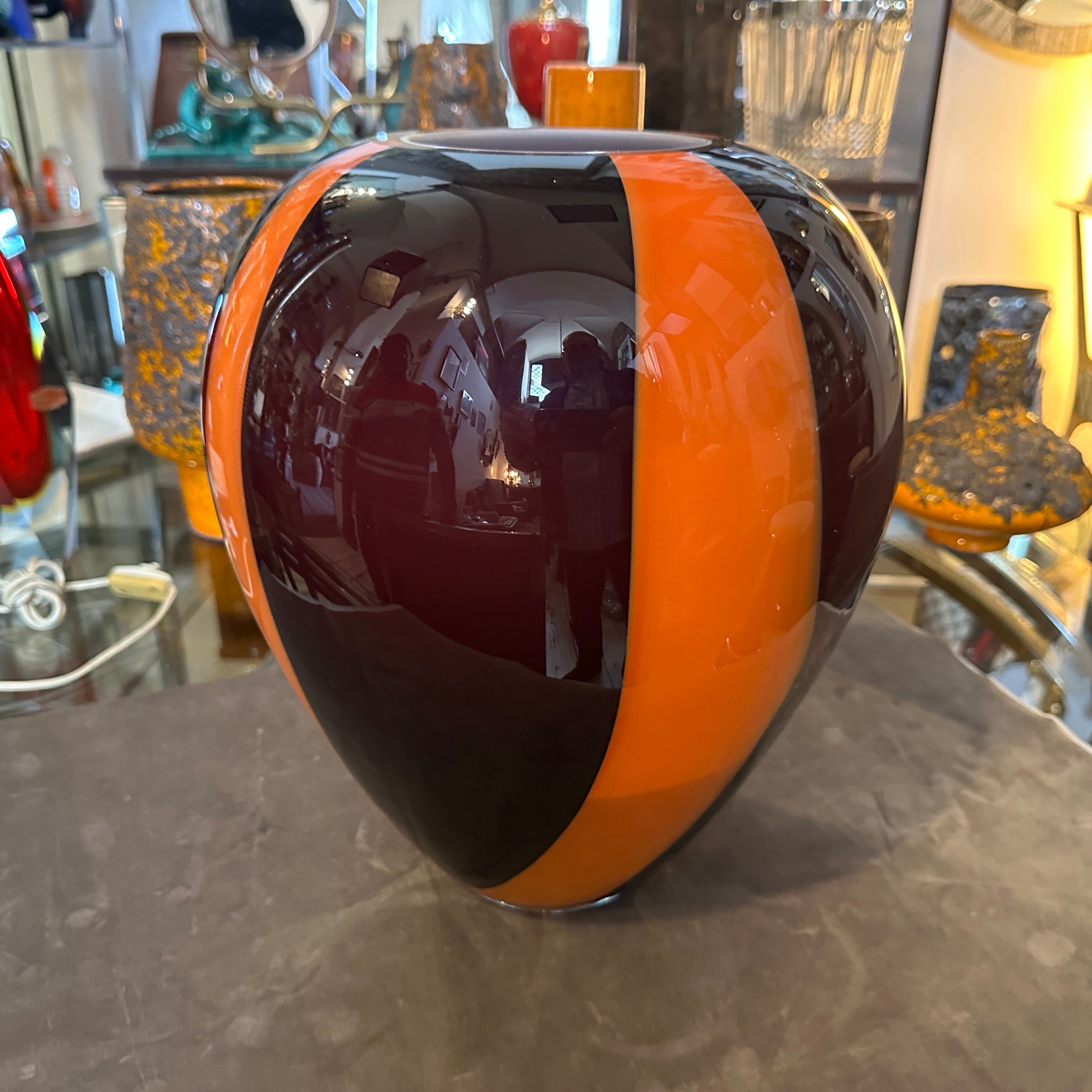 This is a striking 1970s Mid-Century Modern tall Murano glass vase, a prime example of the bold design and craftsmanship characteristic of the era. Made from expertly hand-blown Murano glass, a hallmark of Venetian glass artistry. The glass surface