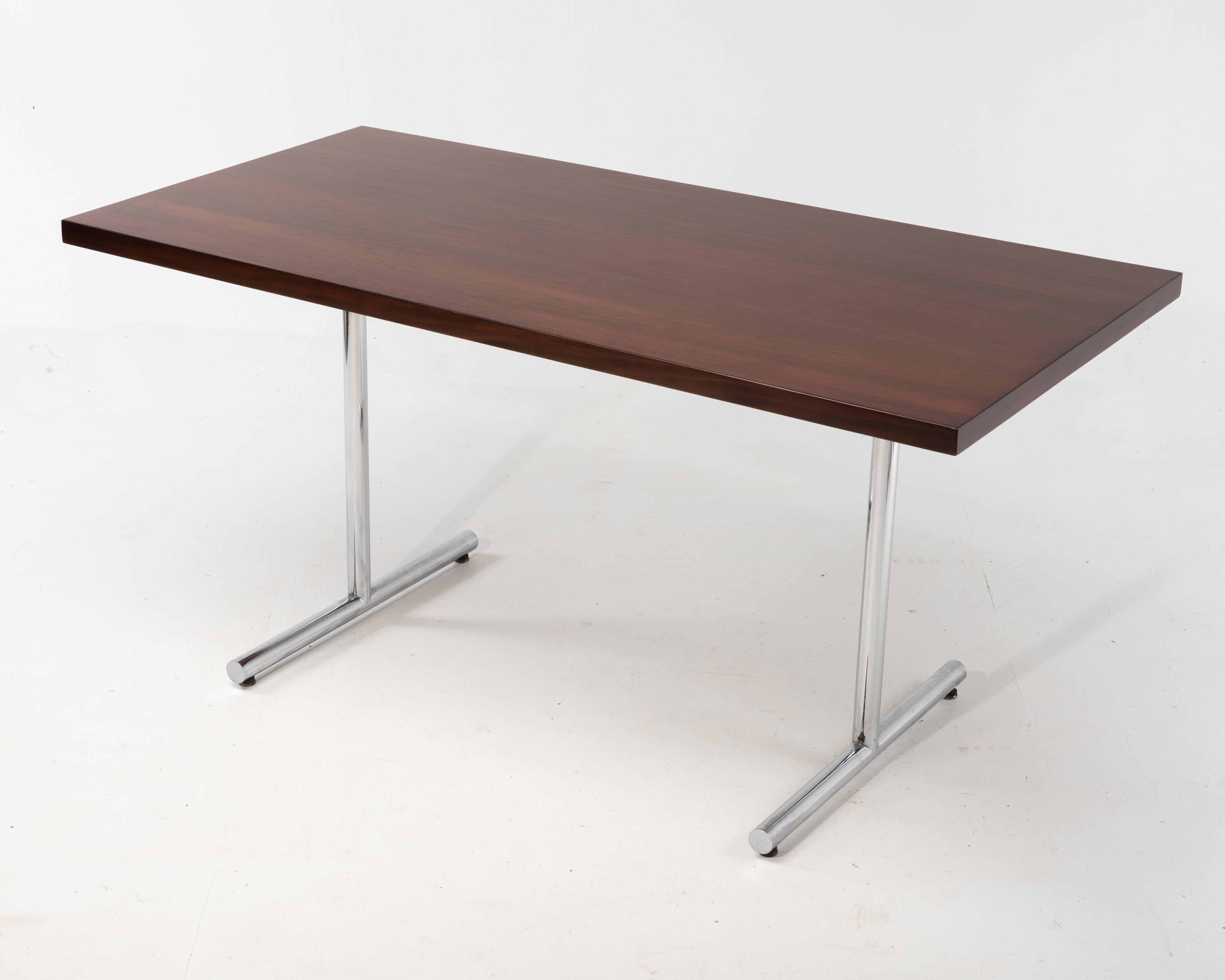 A chrome and rosewood desk from the 1970s. Beautifully book matched top. One single drawer in the center, if removed the desk would make a wonderful dining table. The tag is shown, but we do not see any makers name, nor does it help us attribute it
