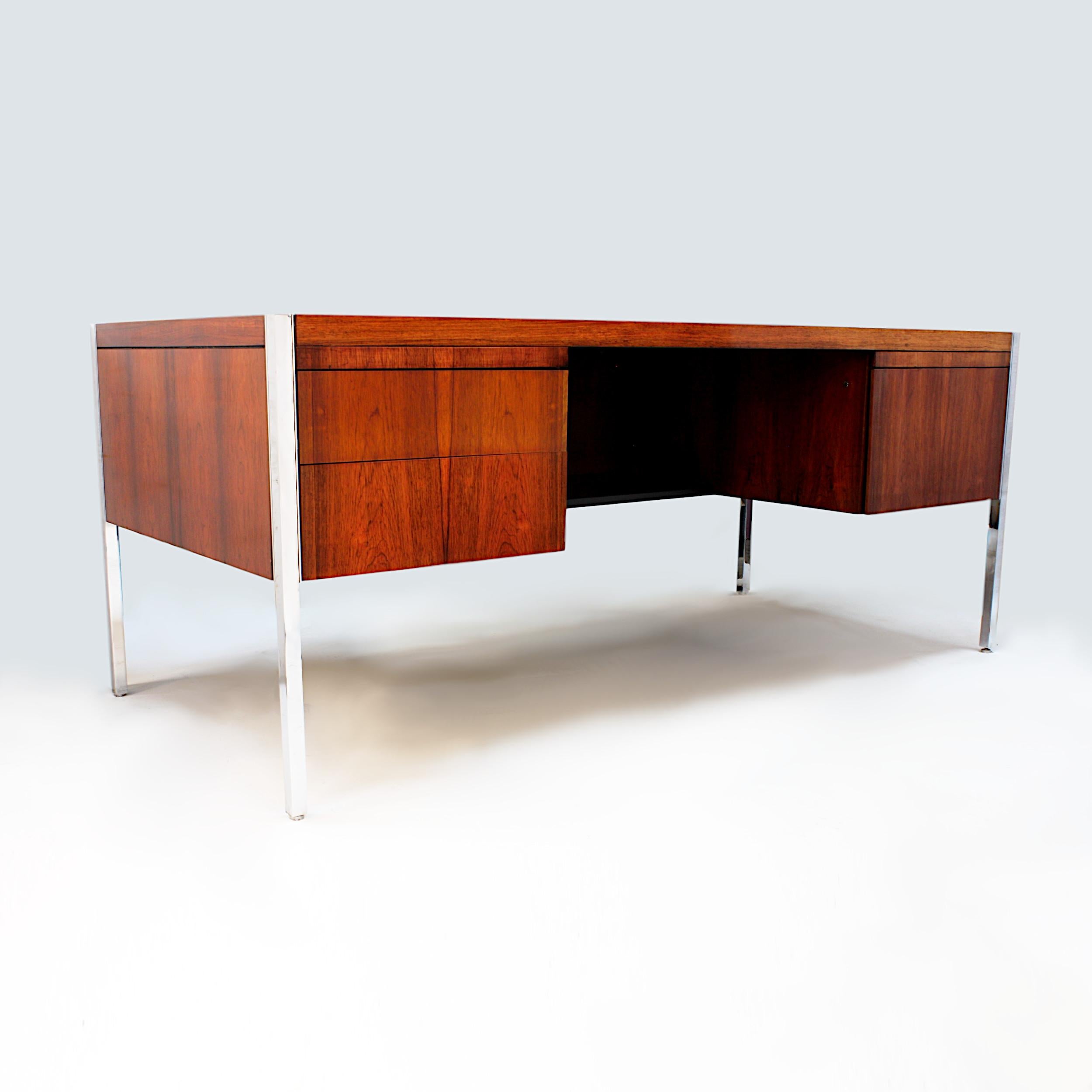 Impressive 1970s vintage executive desk by Richard Schultz for Knoll Associates Inc. Desk features gorgeous rosewood veneer, chrome legs, and unique chrome inlay accents to top. With its Minimalist lines that lets the materials and renowned Knoll