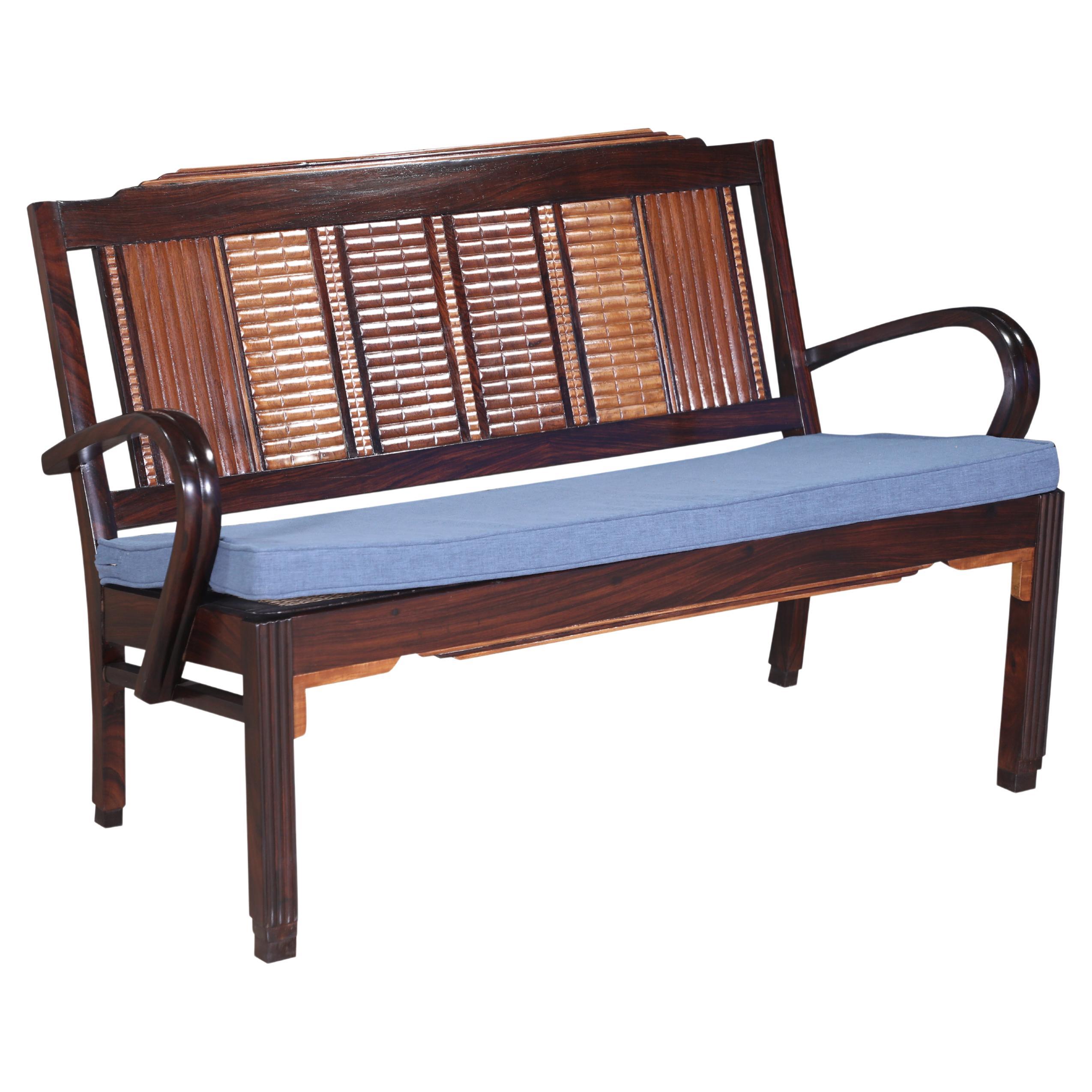 Ein Mid-Century Modern Loveseat aus geschnitztem Teakholz, Satinholz und Palisander mit geschnitzten Sitzen.  Das Caning wird in einem engmaschigen Muster neu gestaltet.  Die Kissen sind aus einem mittelblauen Seiden- und Leinenstoff mit