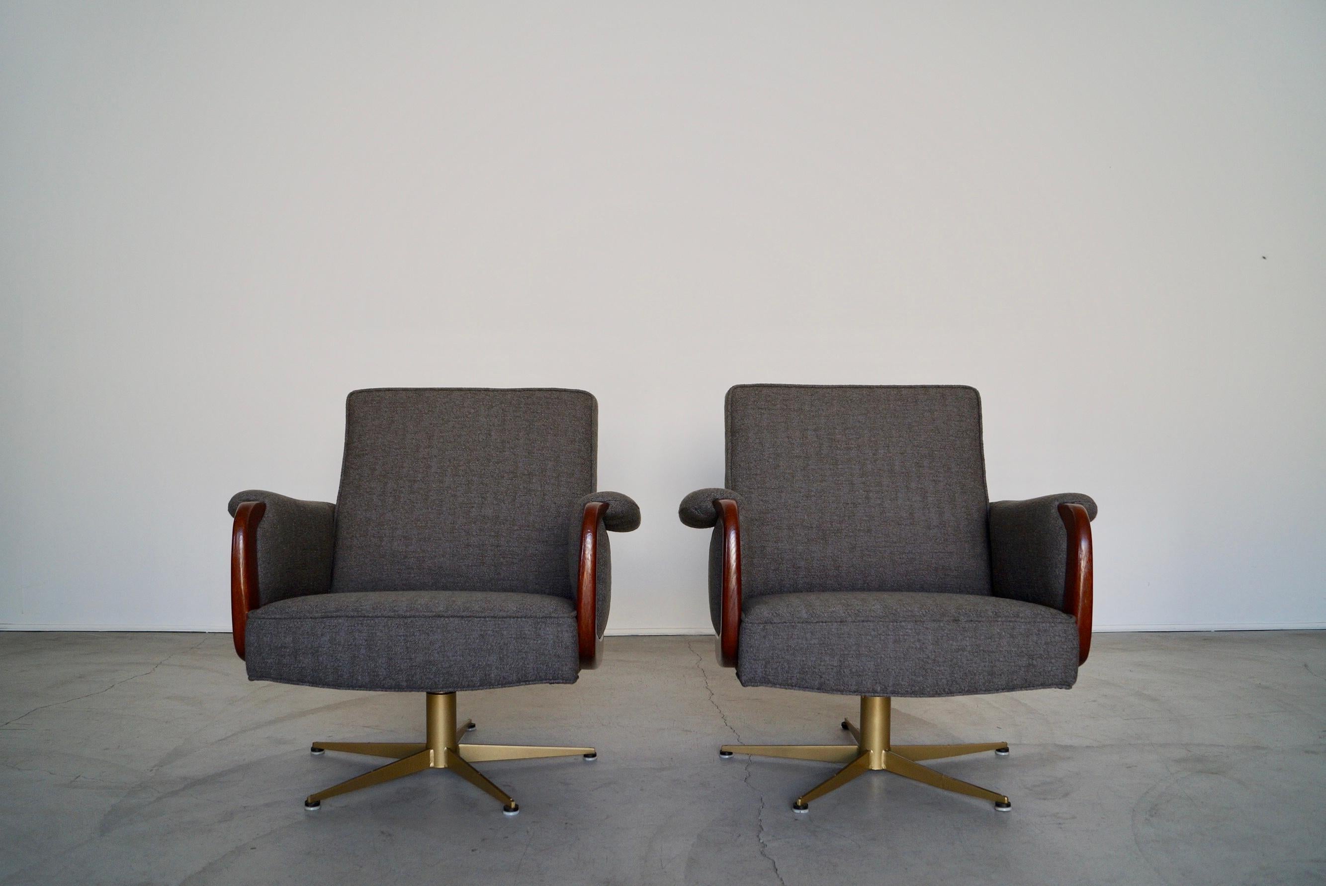 Mid-century Modern lounge chairs for sale. They have been completely restored, and look incredible once again. They have a star atomic base that has been professionally sandblasted and powder coated in a gold brass finish. They have a wood trim on