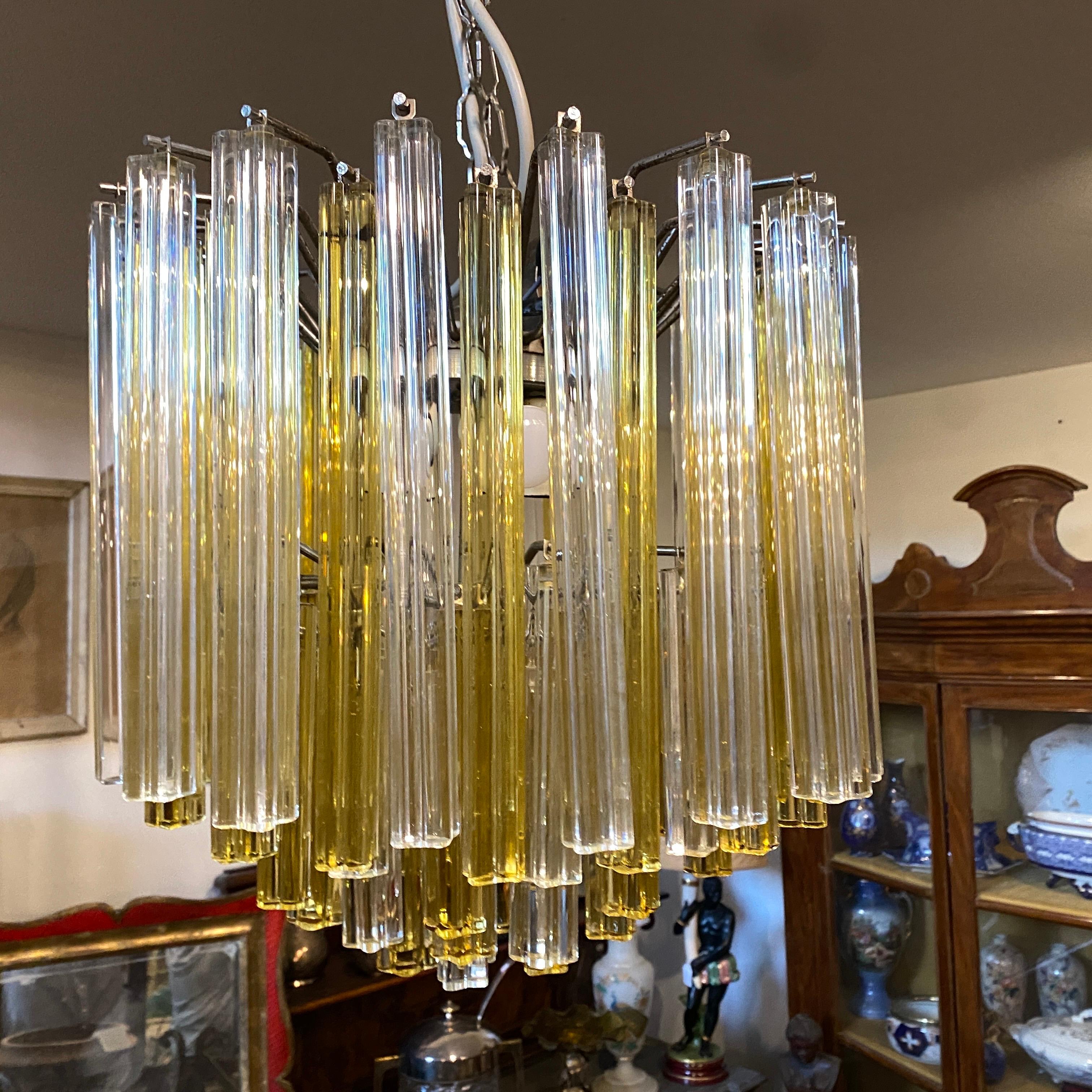 An original venini chandelier made in Murano in the Seventies, all the white and amber glasses are in perfect conditions, the chromed metal structure of the chandelier has normal signs of age. It's in working order, it works 110-240 volts and needs