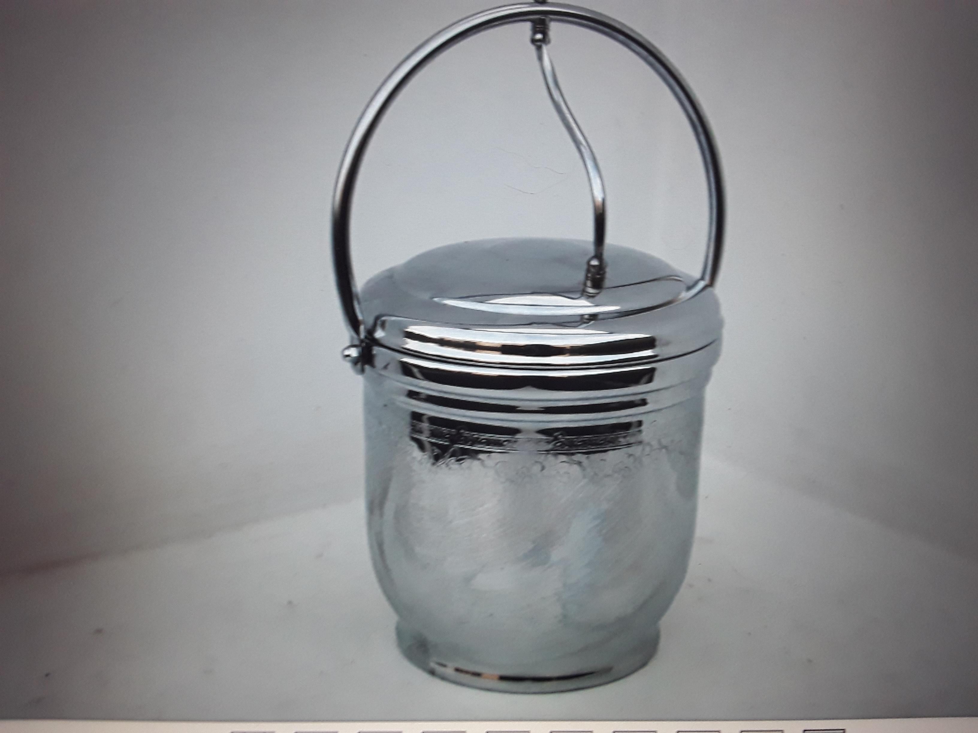 Seau à glace de la société United Solid Brass, datant des années 1970. Liner en verre. Seau chromé décoré.