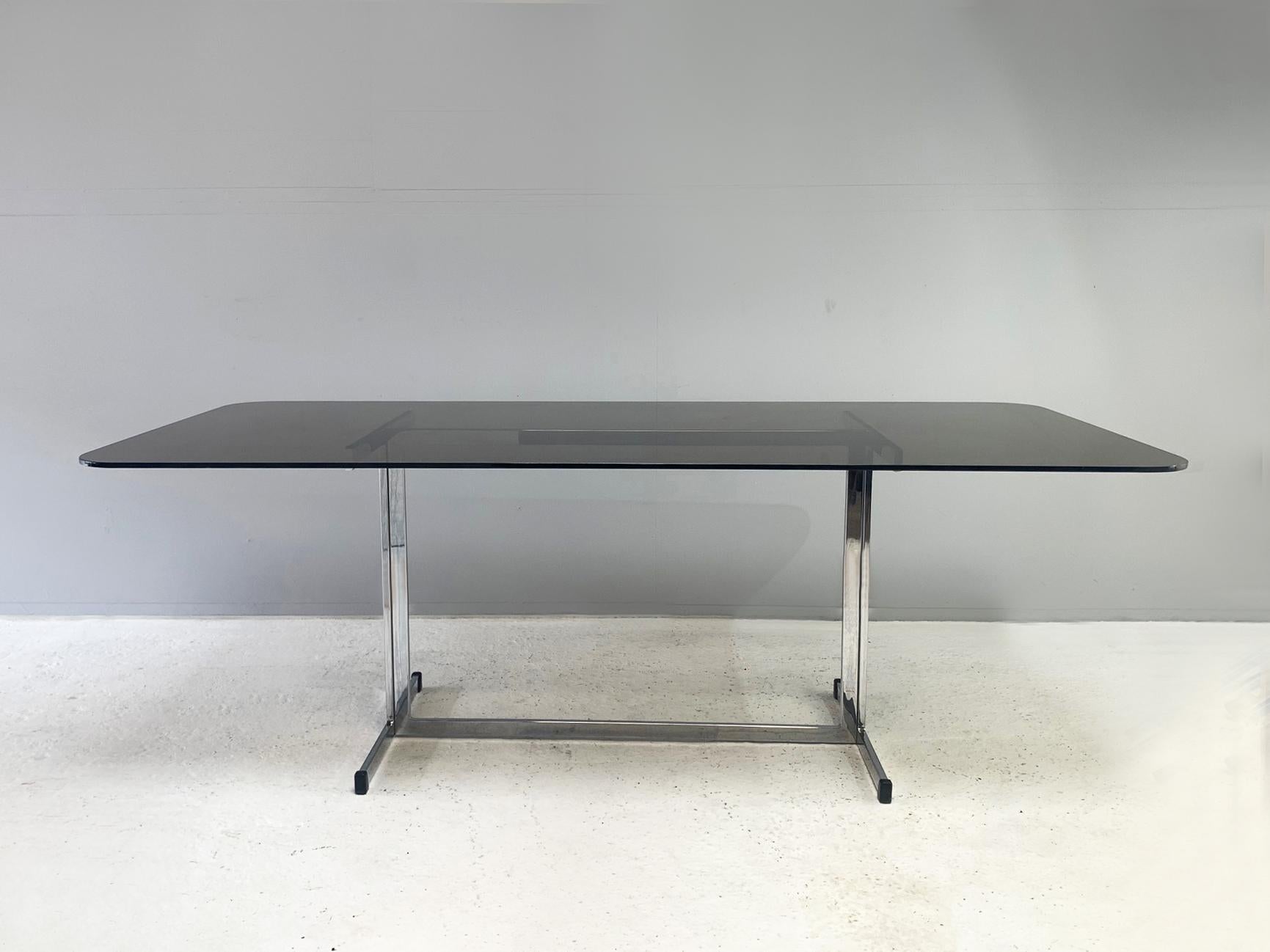 In immaculate condition, this is a 1970’s Tim Bates for Pieff smoked glass and chrome dining table / desk.

Pieff sounds French but is very British. Tim Bates and his family designed and manufactured cutting edge, sleek and minimal pieces from the