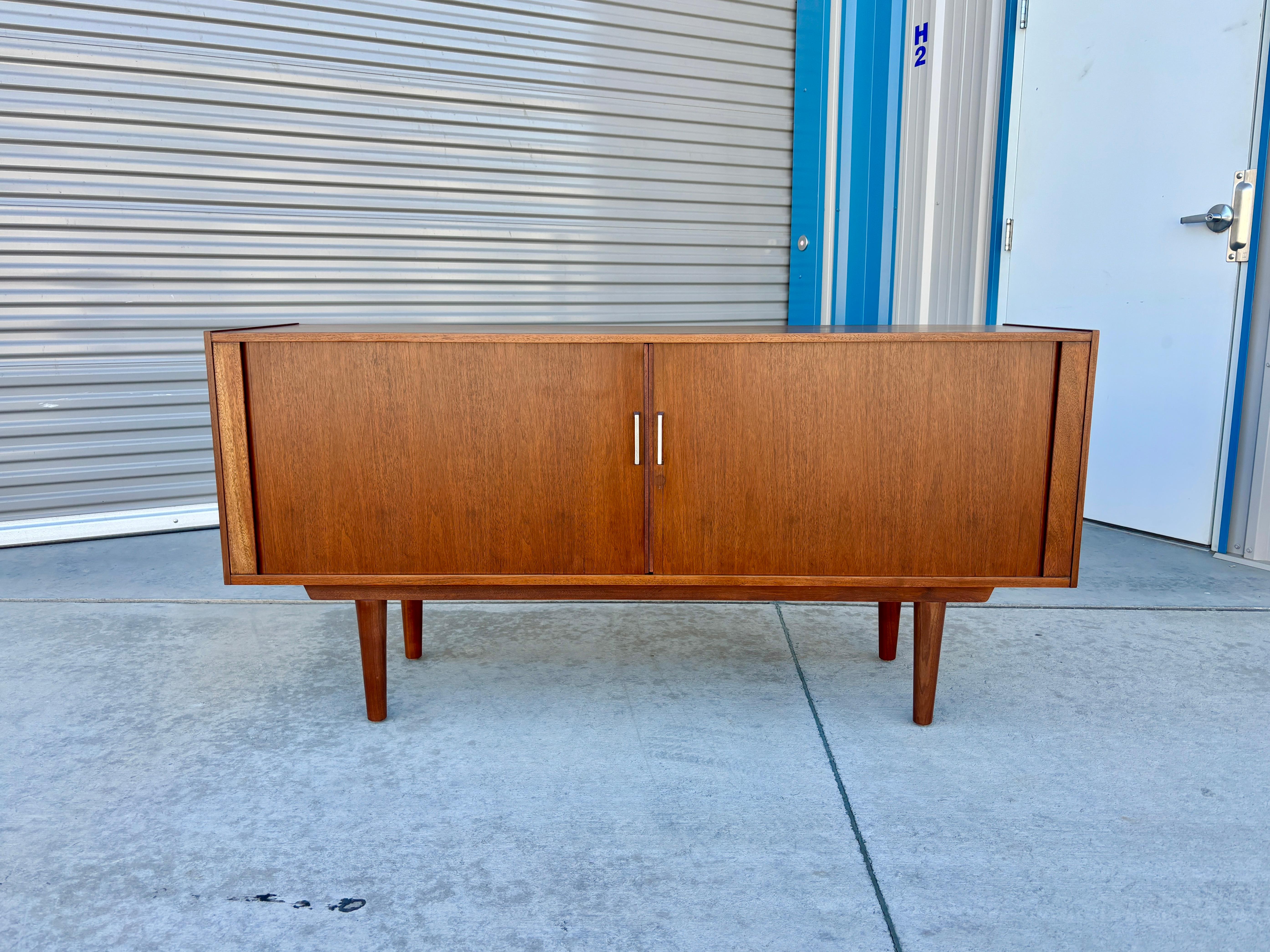 Willkommen im Mid-Century NoHo

[Mid-Century Walnuss Tambour Tür Credenza]

Diese Kredenz aus Nussbaumholz mit Rollladen wurde in den 1970er Jahren in den Vereinigten Staaten entworfen und hergestellt. Das warme Walnussholz und die schlanken