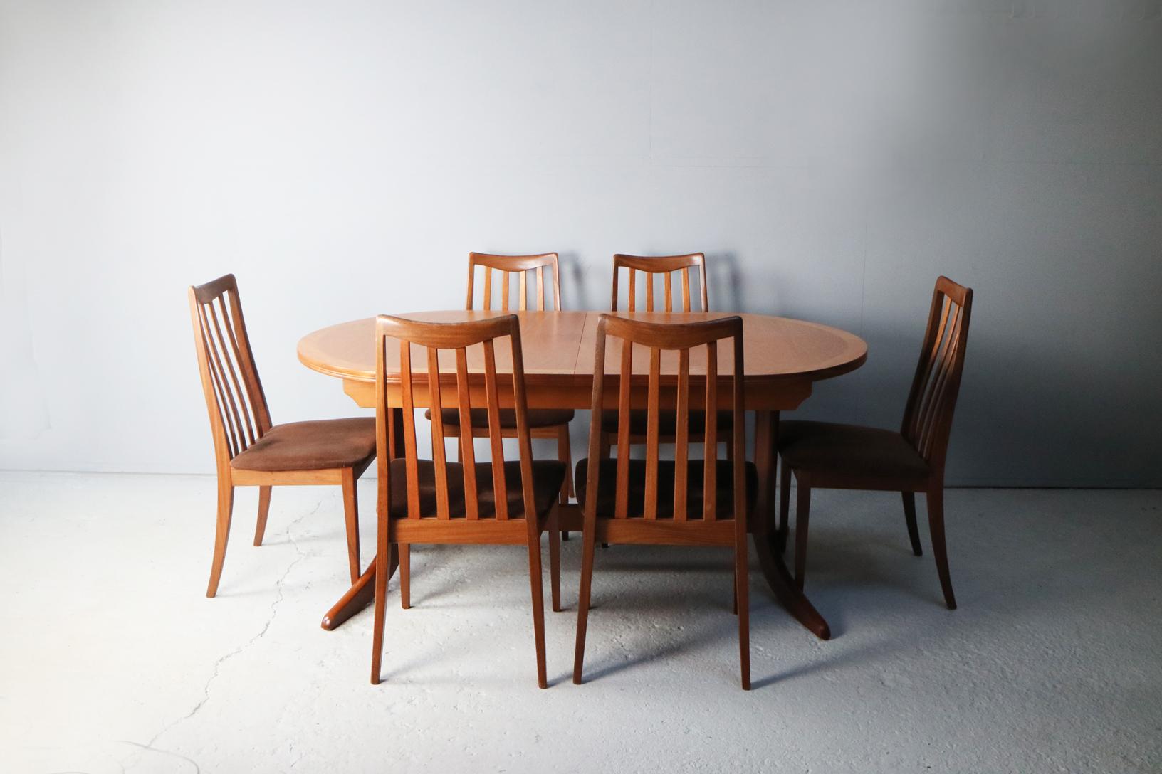 A large Nathan extending dining table in excellent condition, and 6 G Plan chairs with brown velour original seating and distinctive back rests.

Measures: Table: width extended 208cm x width unextended 162.5cm depth 104cm x height 74cm
Chairs: