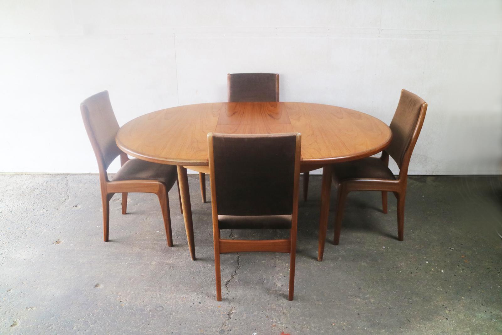 A G plan extending teak dining table with a matching, very elegant set of dining chairs upholstered in the original mushroom coloured velour. The sculpted frames are in polished teak.

Size chairs: Width 47cm x depth 53cm x height 91cm x seat