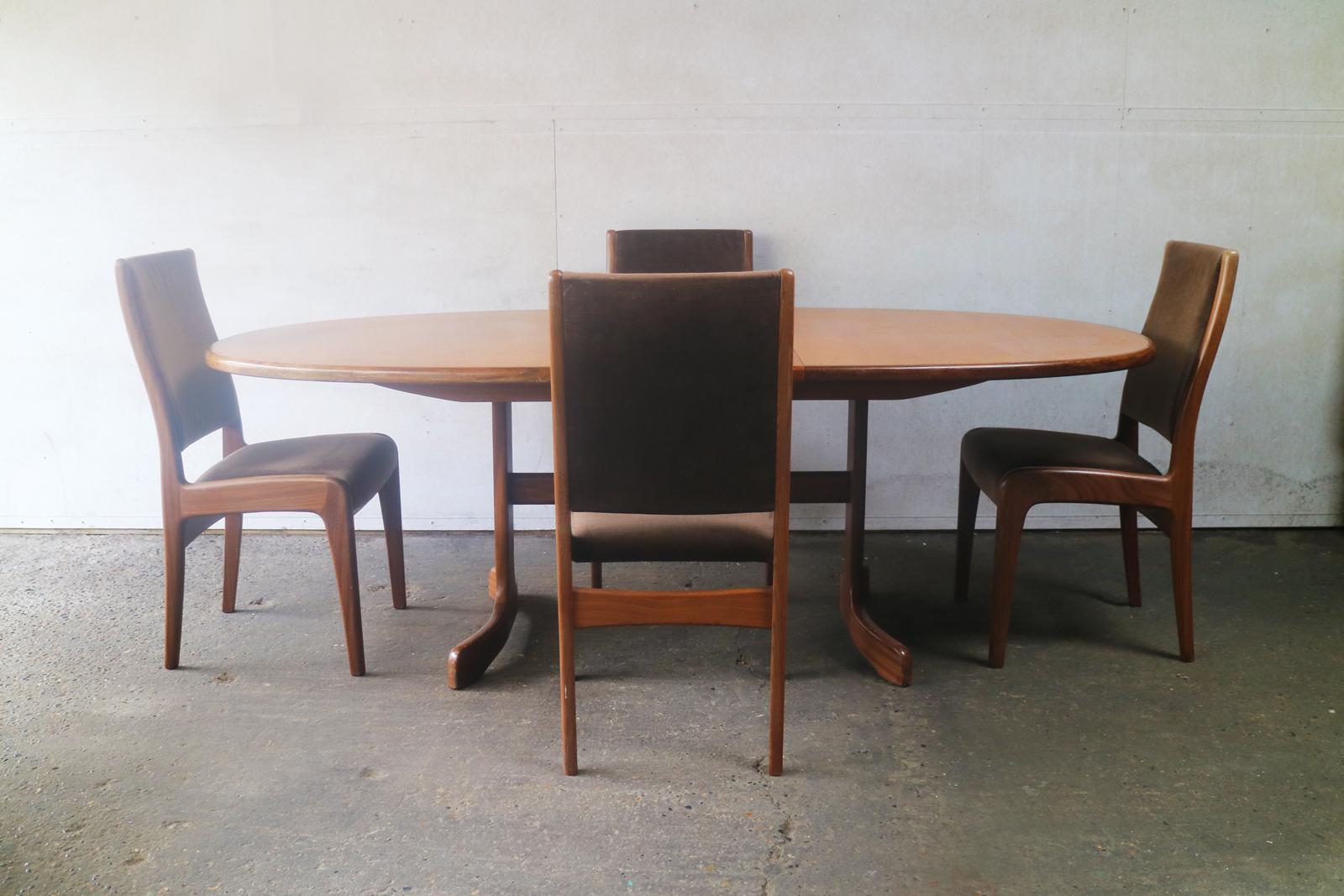 A large G plan extending ellipse shaped teak dining table with a matching, very elegant set of dining chairs upholstered in the original mushroom colored velour. The sculpted frames are in polished teak.

The dining table has a lovely smooth
