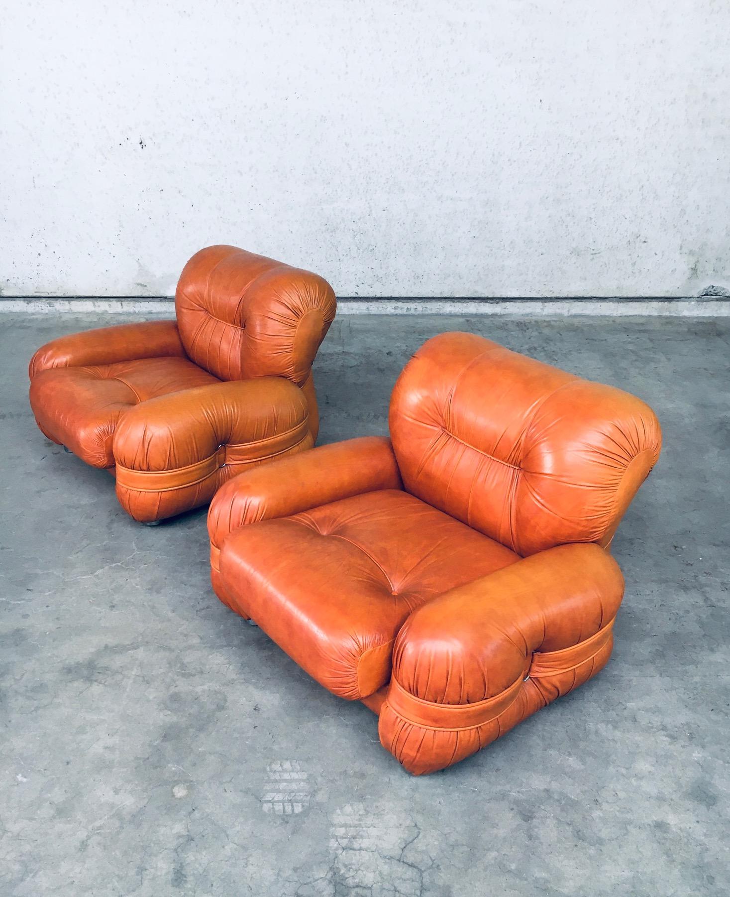 Vintage Midcentury Modern Italian Design Leather Lounge Chair set of 2. Made in Italy, 1960's / 70's period. Cognac leather arm chairs with straps and buckles on the side rests. Bulbous shapes on this very comfy and beautiful lounge chairs. These