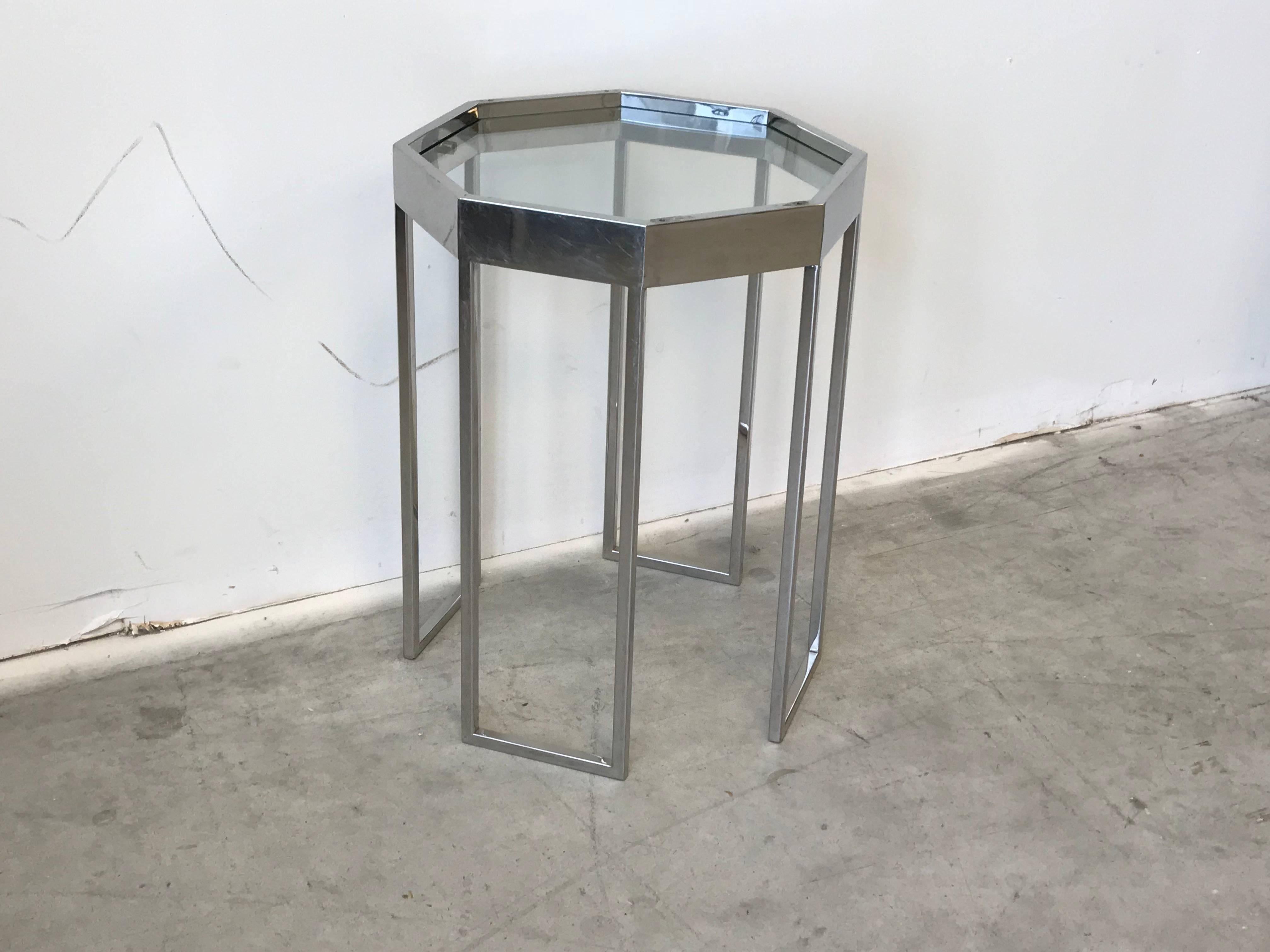 Listed is a stunning and unique, 1970s Milo Baughman chrome octagonal cocktail side table. Glass top. On two sides of the chrome top, there are two holes on each side (see photo 3)-- looks as if there were handles at some point in time. Buyer can
