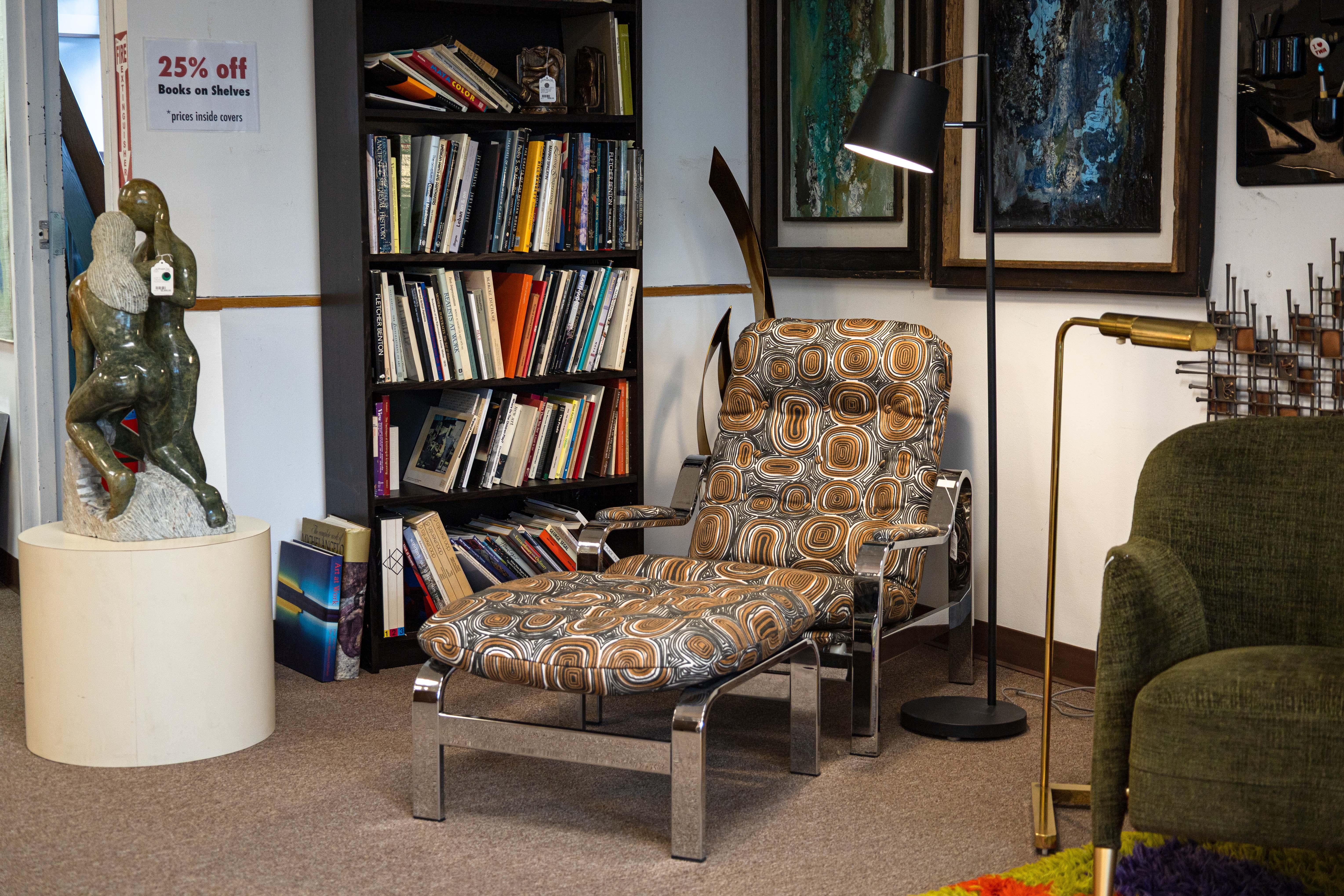 A Milo Baughman for Selig 1970s reclining lounge chair. This very 70s accent lounge chair features a flat bar chrome frame design with a chic swirling abstract print design throughout the cushions. It also features upholstered cushions on the arm