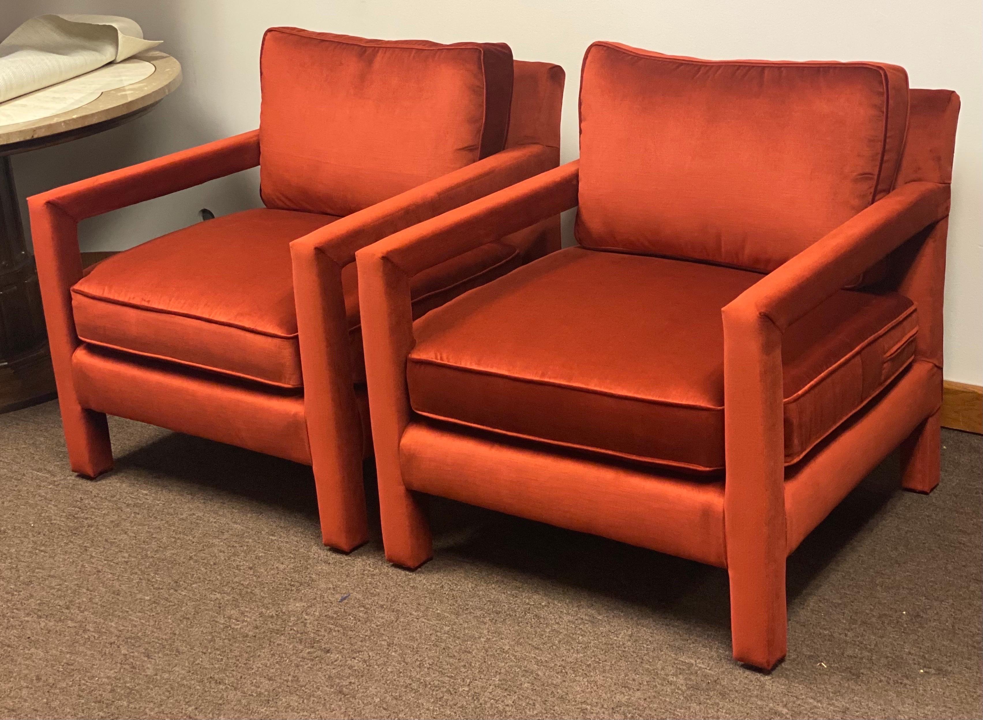 We are very pleased to offer an iconic pair of Milo Baughman style chairs, circa the 1970s. The parson lounge pair is a stylish modern armchair with a wraparound upholstered frame and a comfortable feel. This fabulous set is newly reupholstered in a