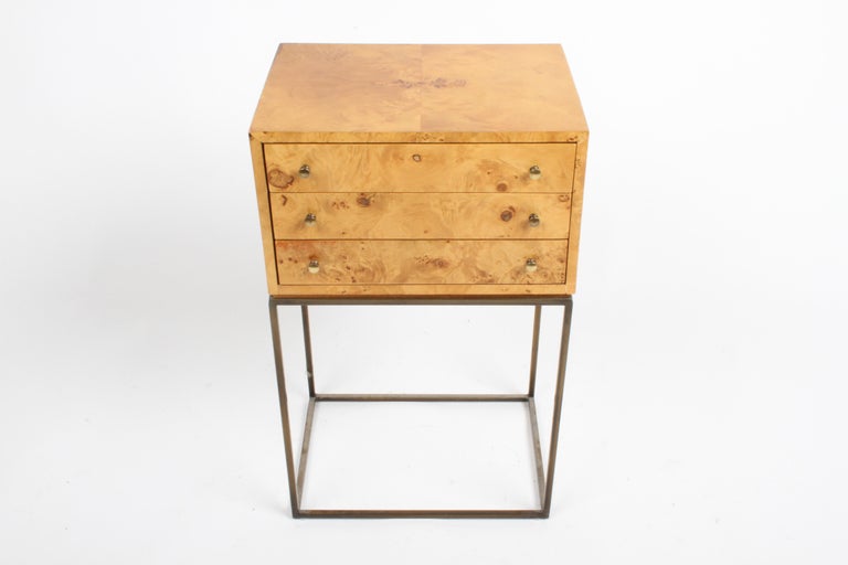 1970s Mid-Century Modern small three drawer Burled Elm Jewelry chest on brass square tubing base / stand in the style of Milo Baughman. The small chest appears to float on the brass tubing, its veneered in Burled Elm, has brass knobs, sides of chest