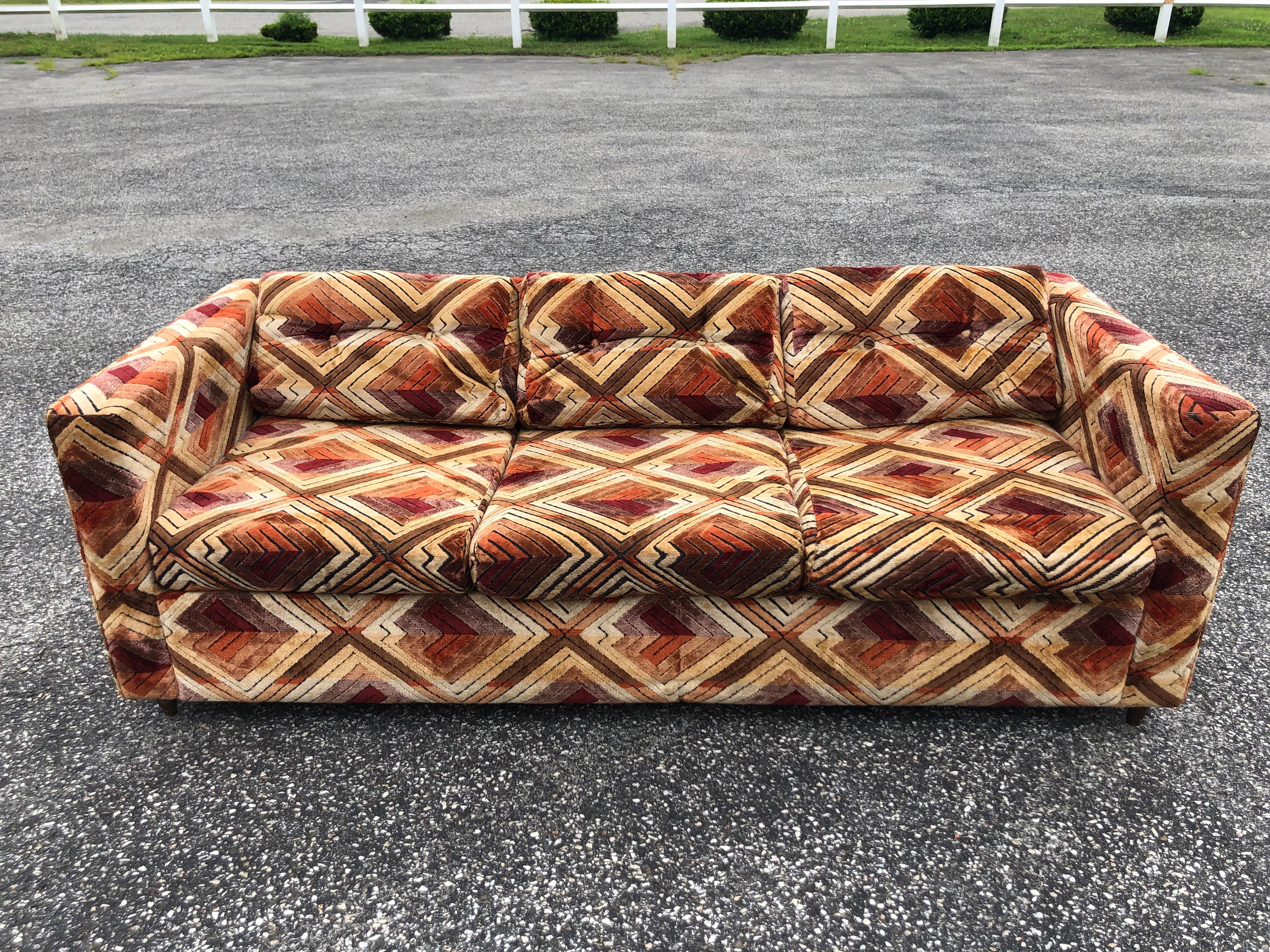 1970s Milo Baughman style sofa with Jack Lenor Larsen Upholstery. Chevron patterned velour/velvet style. So retro 1970s. Perfect for the mod set design. Pulls out to a sofa bed. Some wear to underside of pillows. So foam is showing through. Please
