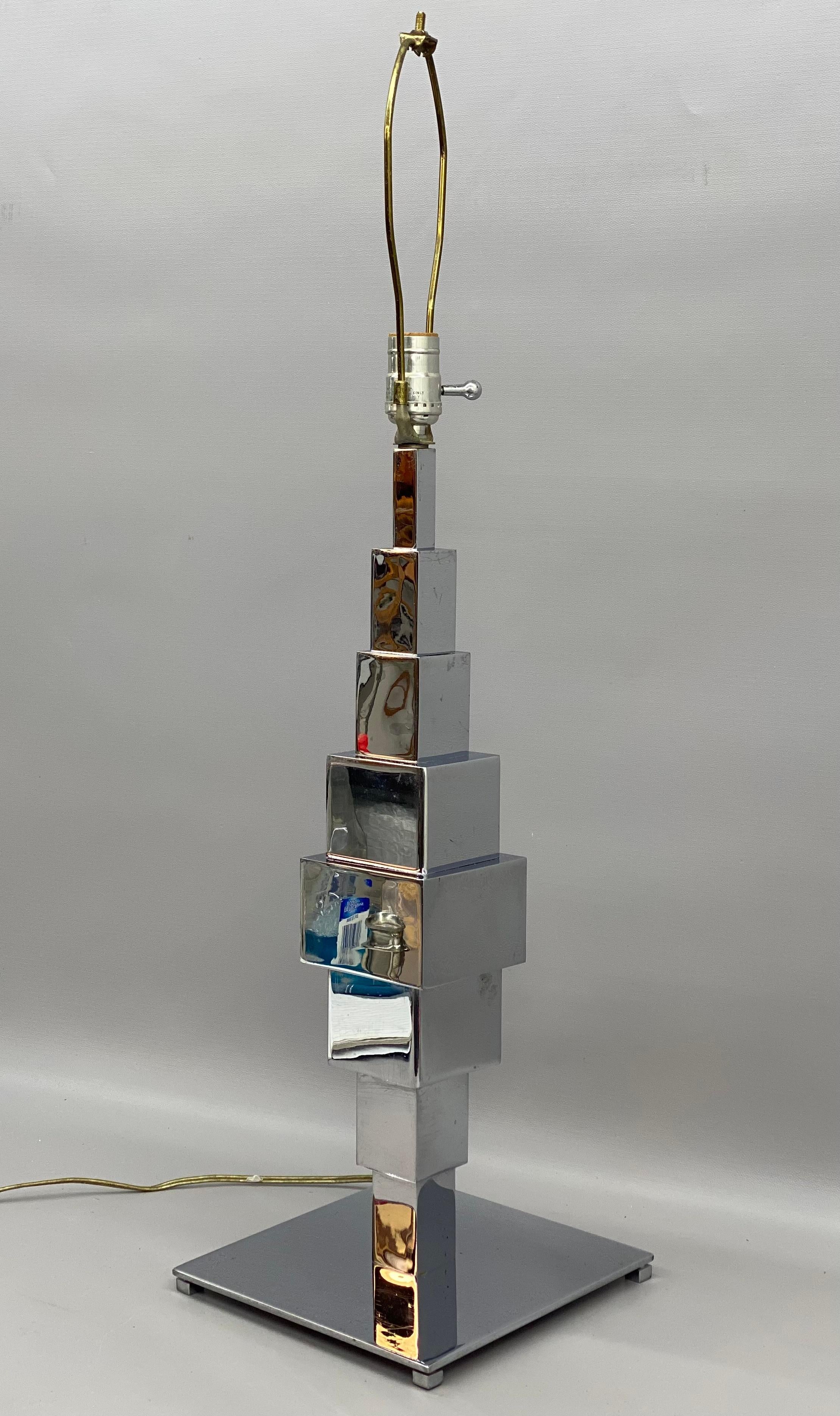 Curtis Jere style Skyscraper table lamp. Circa 1970-80. A quality, heavy duty mirrored chrome finished lamp. Stacked cubes with the largest in the middle of the body of the lamp.

Good overall condition. Some minor scratches and scuffs. Some minor