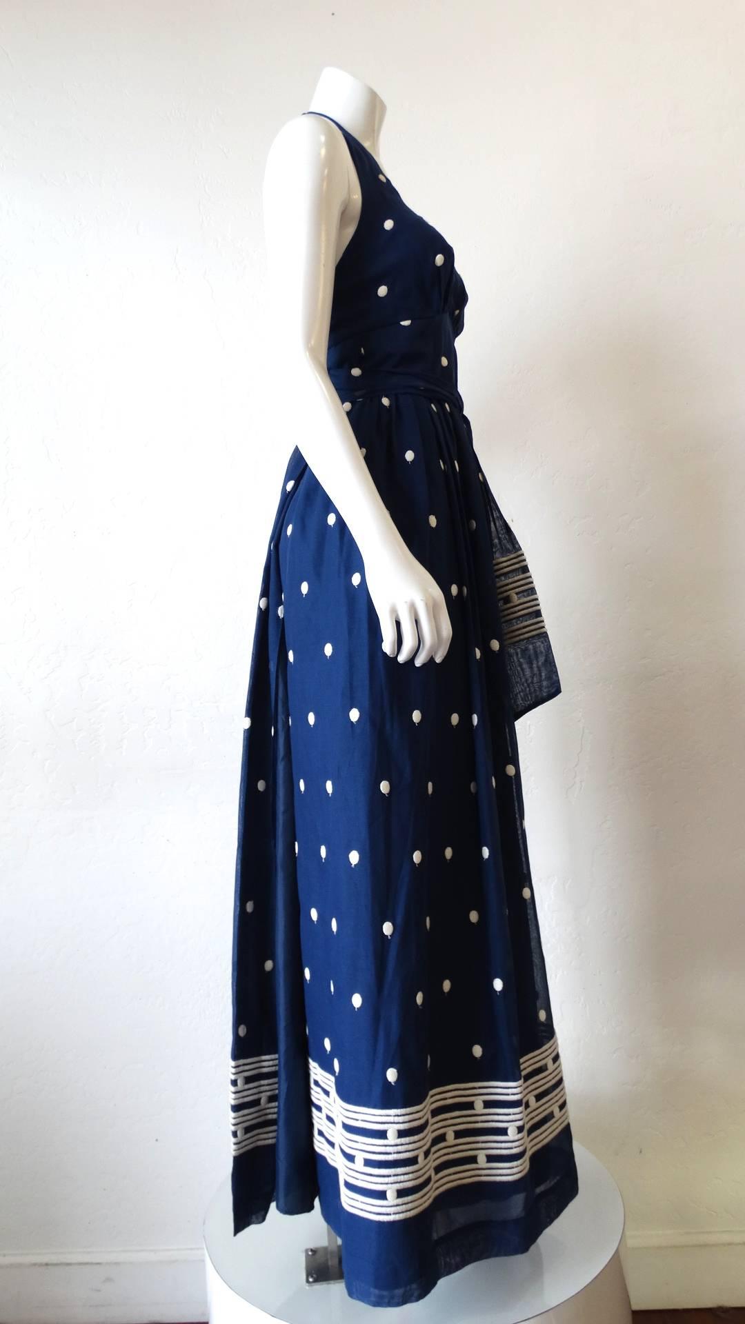 Your perfect summer frock has arrived! From California designer Miss Elliette, this piece is straight out of the 1970s! Made of a solid blue cotton fabric embroidered with a white polka dot print and stripes along the hem/sash. Matching sash ties