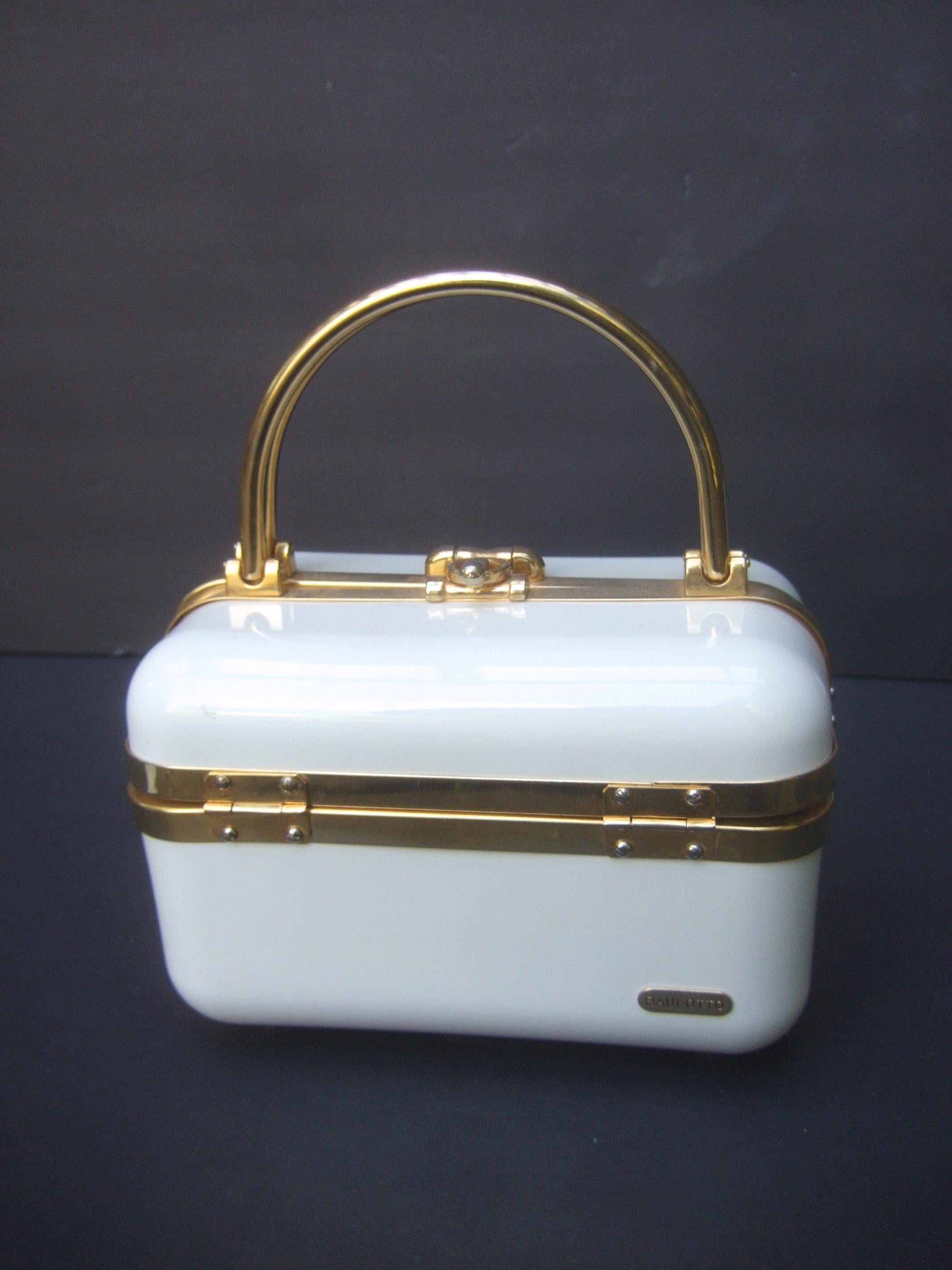 1970s Mod Italian molded resin box purse designed by Baulotto  
The sleek Italian white plastic box purse is accented with gilt
metal swivel handles and hardware 

The interior is lined in vinyl designed with a zippered compartment 
Makes a bold