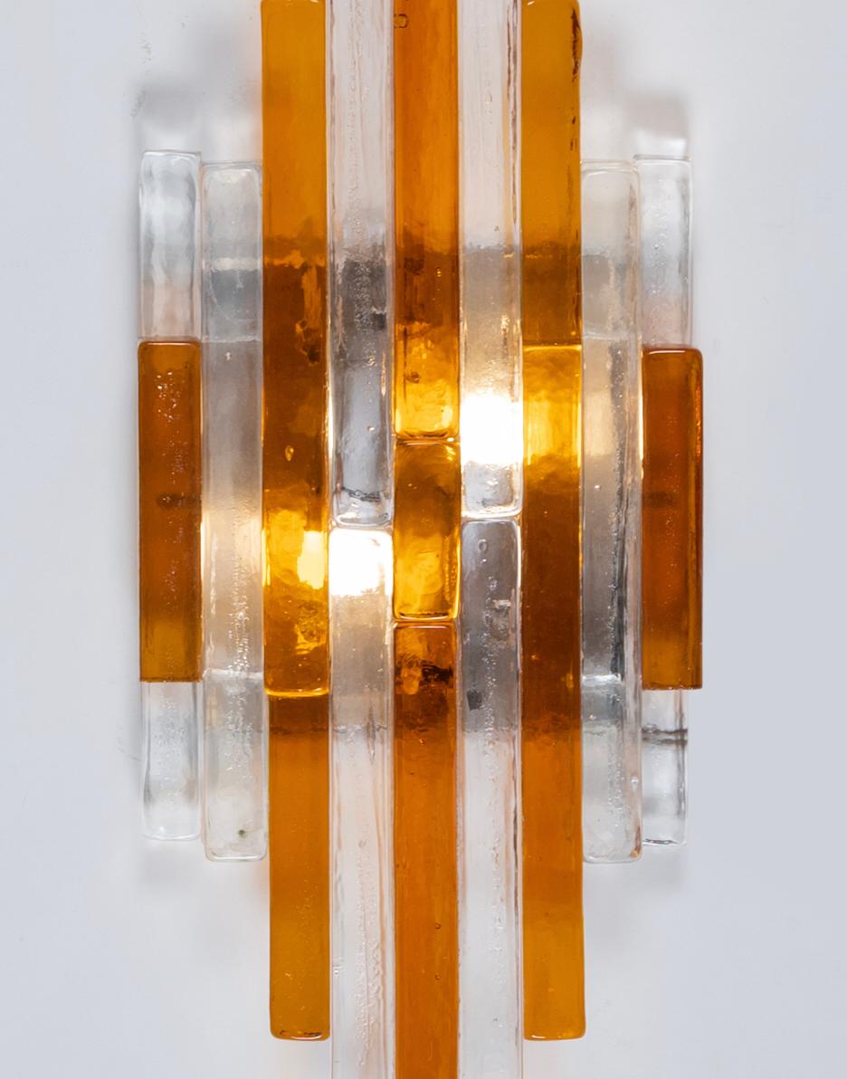 Monumental stacked glass Linea wall sconces designed by Albano Poli and manufactured in Italy in the Seventies by Poliarte Verona. The 'Linea' wall sconces feature wands of handmade  and maber transparent glass, meticulously arranged to create a