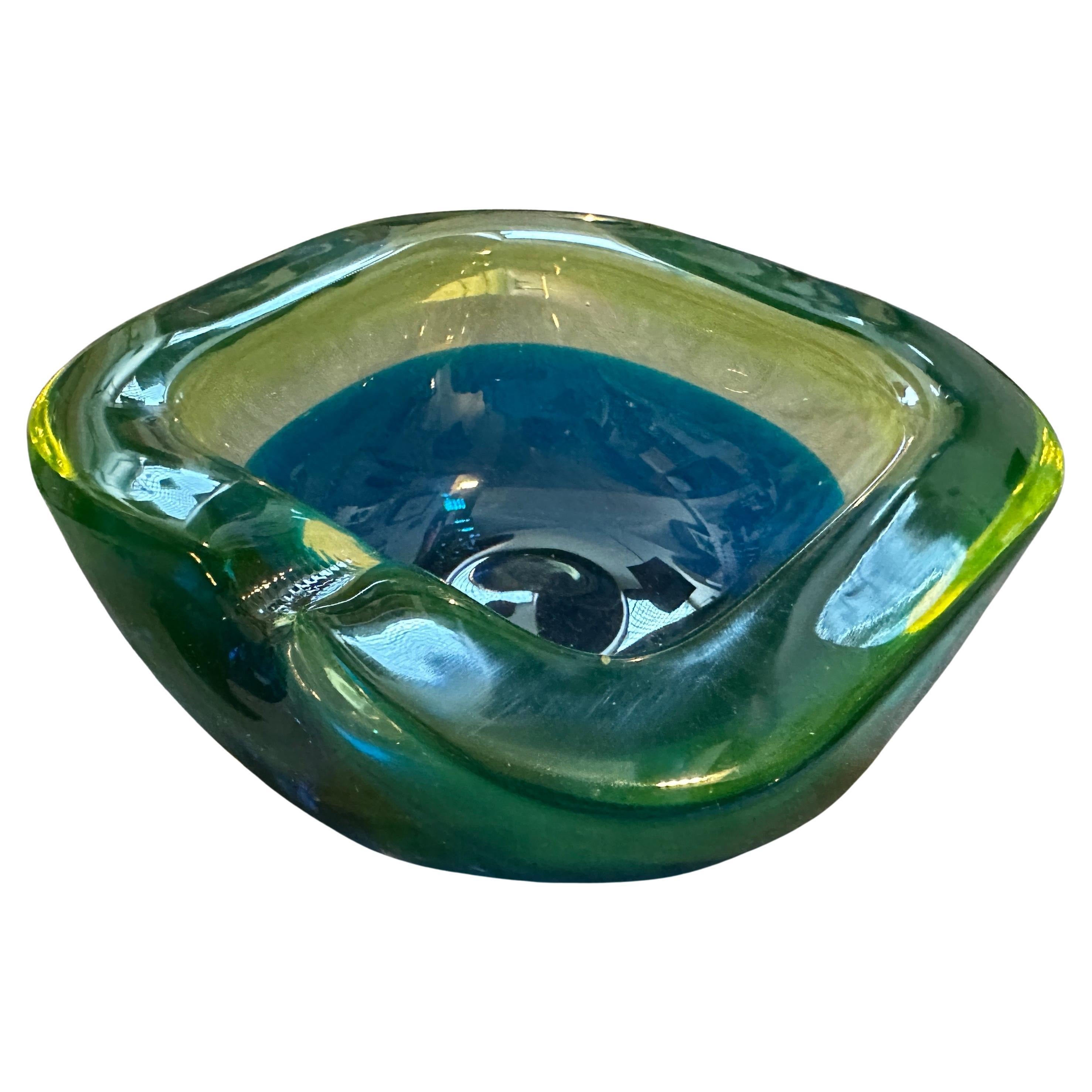 Ce superbe cendrier en verre de Murano des années 1970, attribué à la manufacture Seguso, incarne le style vibrant de l'ère moderne du milieu du siècle dernier. Réalisée selon la célèbre technique Sommerso, cette pièce présente une étonnante couche