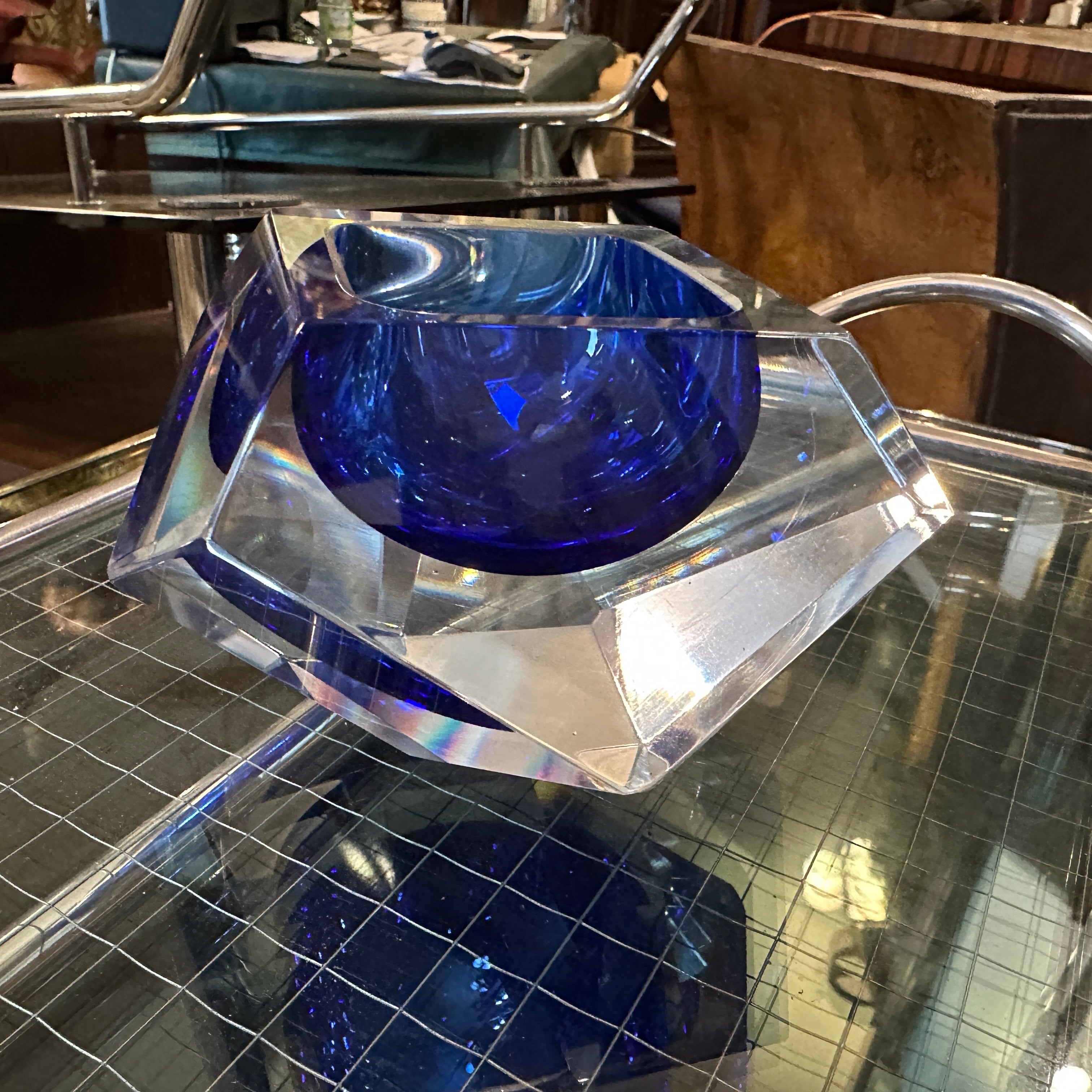 A faceted blue sommerso murano glass ashtray designed and manufactured by Seguso in perfect conditions. Crafted with precision and artistry, the ashtray boasts a multifaceted surface that catches and reflects light, adding depth and dimension to its