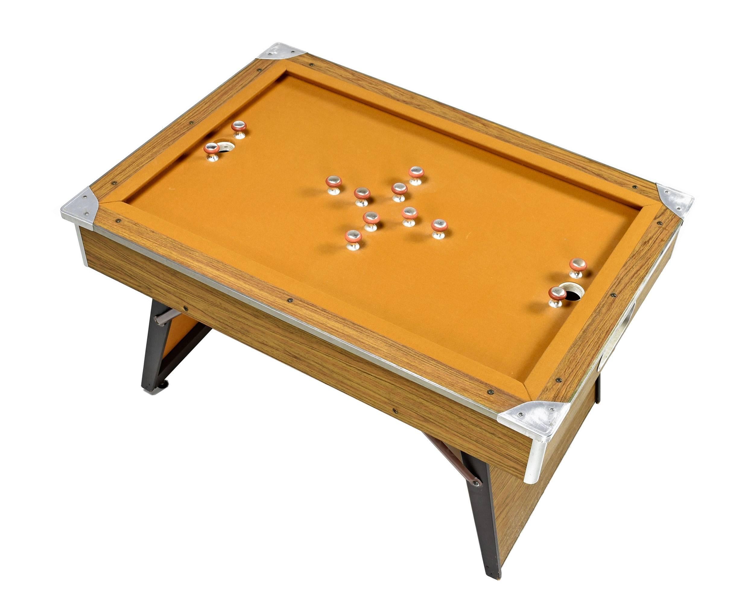 This super stylish modern 1970s vintage bumper pool table is a rare find, and much more accommodating than a standard pool table. The table features the original mustard yellow felt, and comes complete with cue sticks and balls. The legs fold
