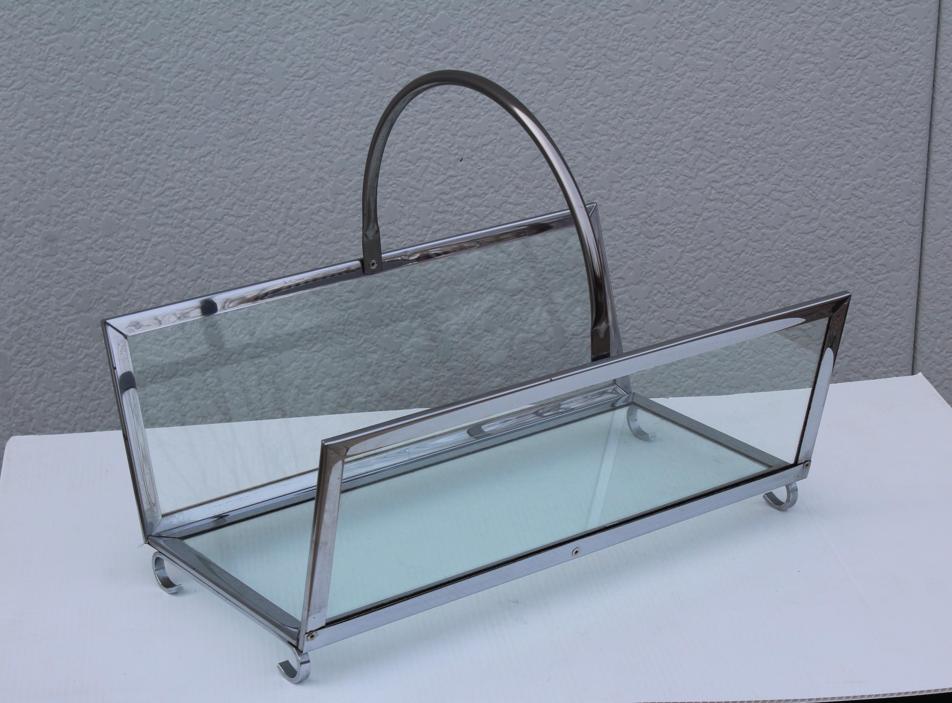 1970s modern chrome and glass log holder with scrolled feet, well made and very heavy. 

Measures: Height including handle 16
